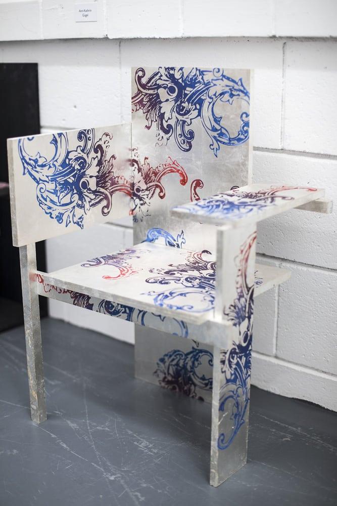 A metal chair with floral blue and red patterning.
