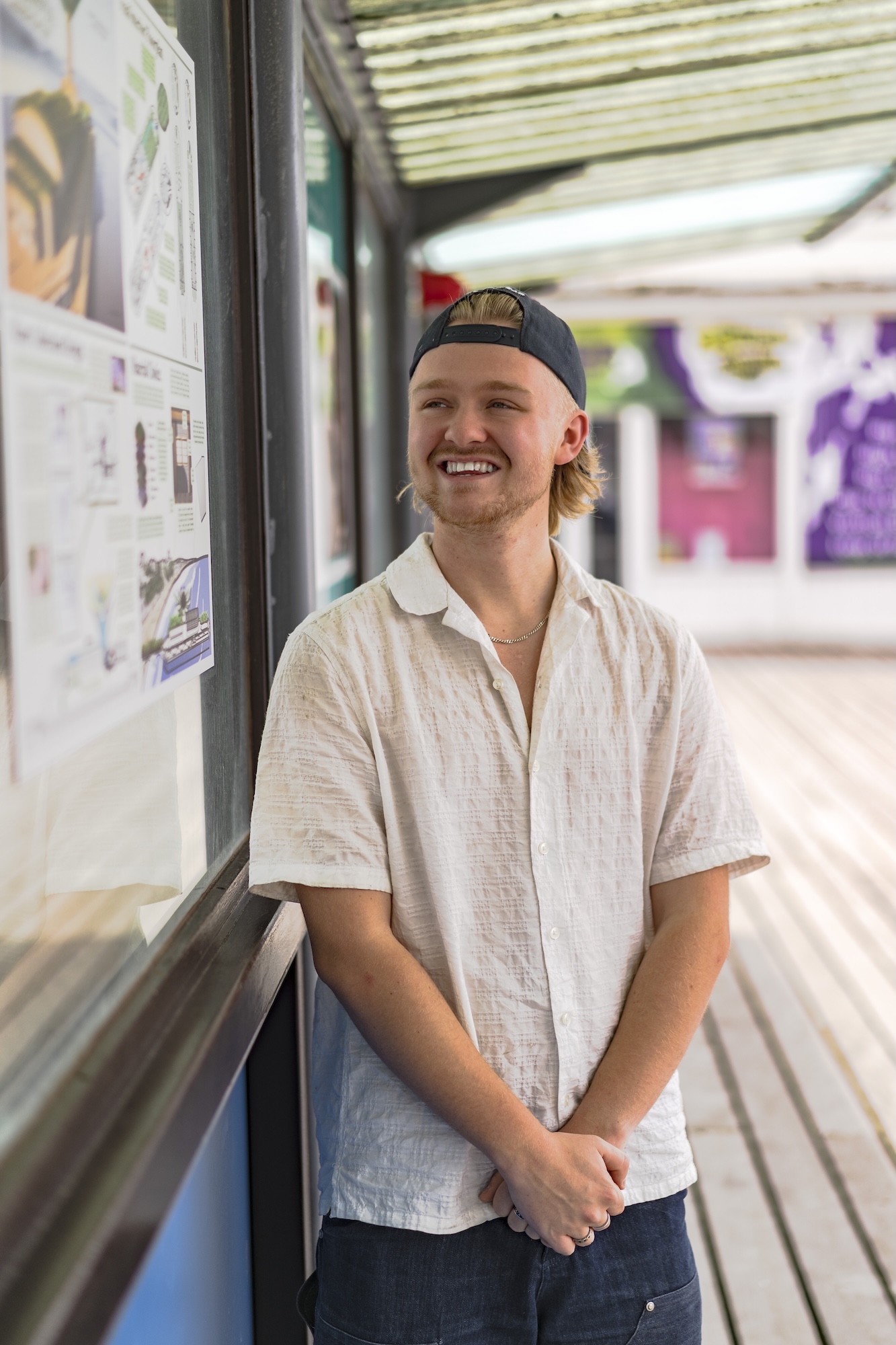 Portrait of A. Ayles standing next to a display board on Bournemouth Pier.