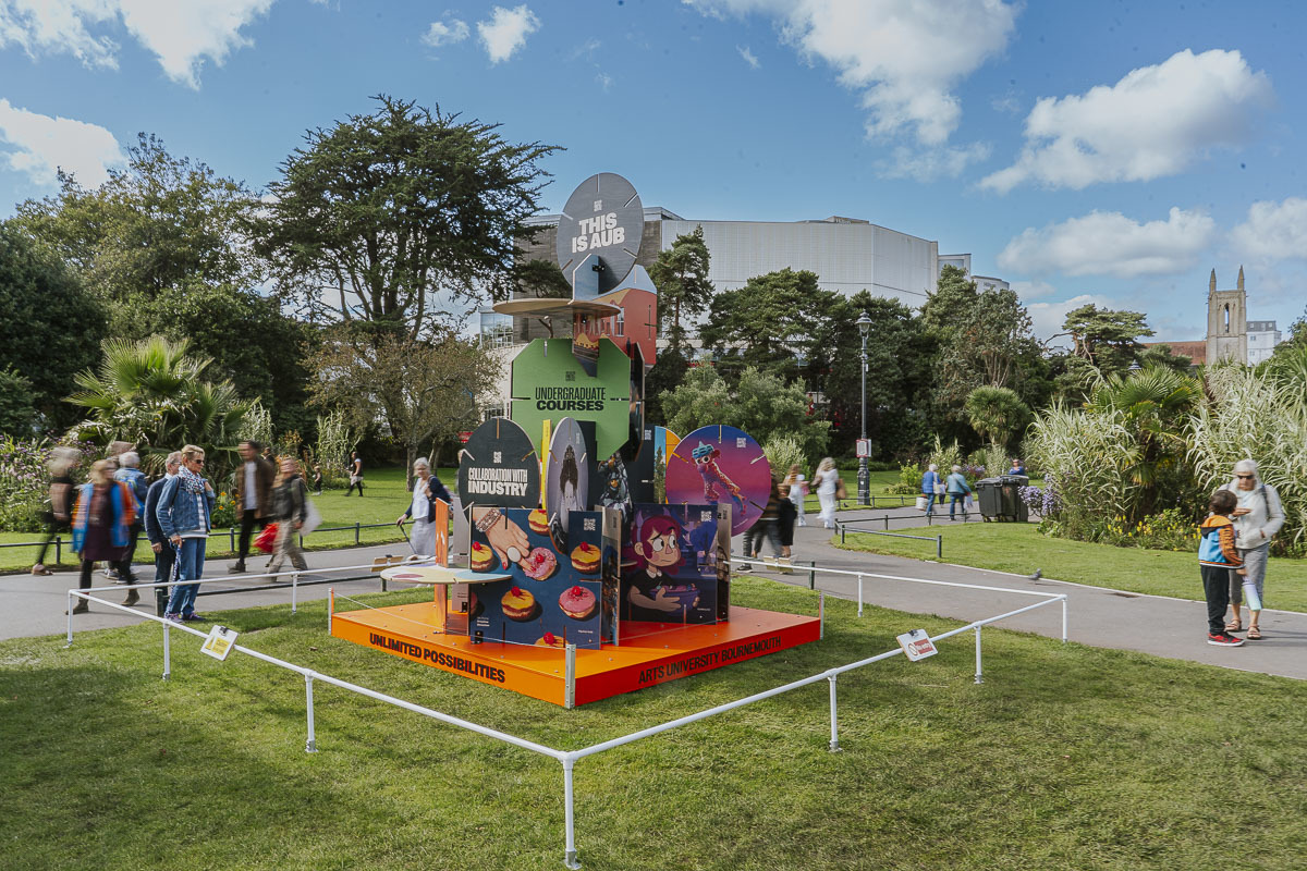 A sculpture illustration based on Arts University Bournemouth's House of Cards prospectus, on an orange pedestal, in Bournemouth's Lower Gardens