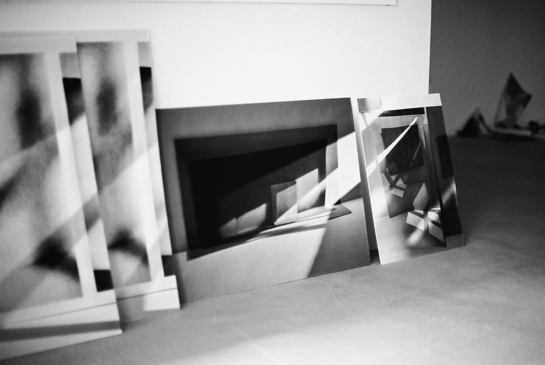 Four black-and-white photos printed on canvas leant up against a wall.