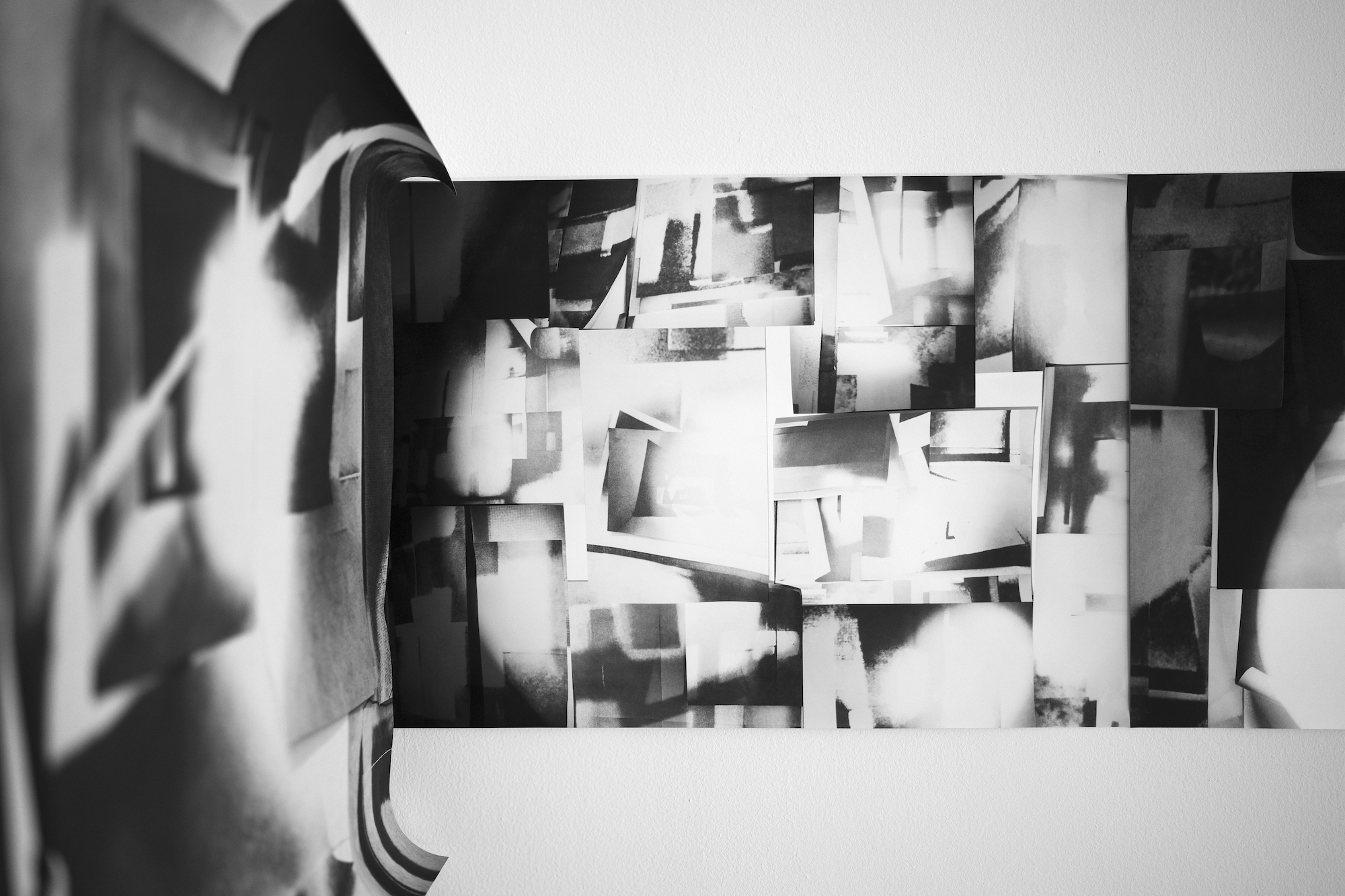 Close-up of a set of black and white abstract images stuck to a wall.