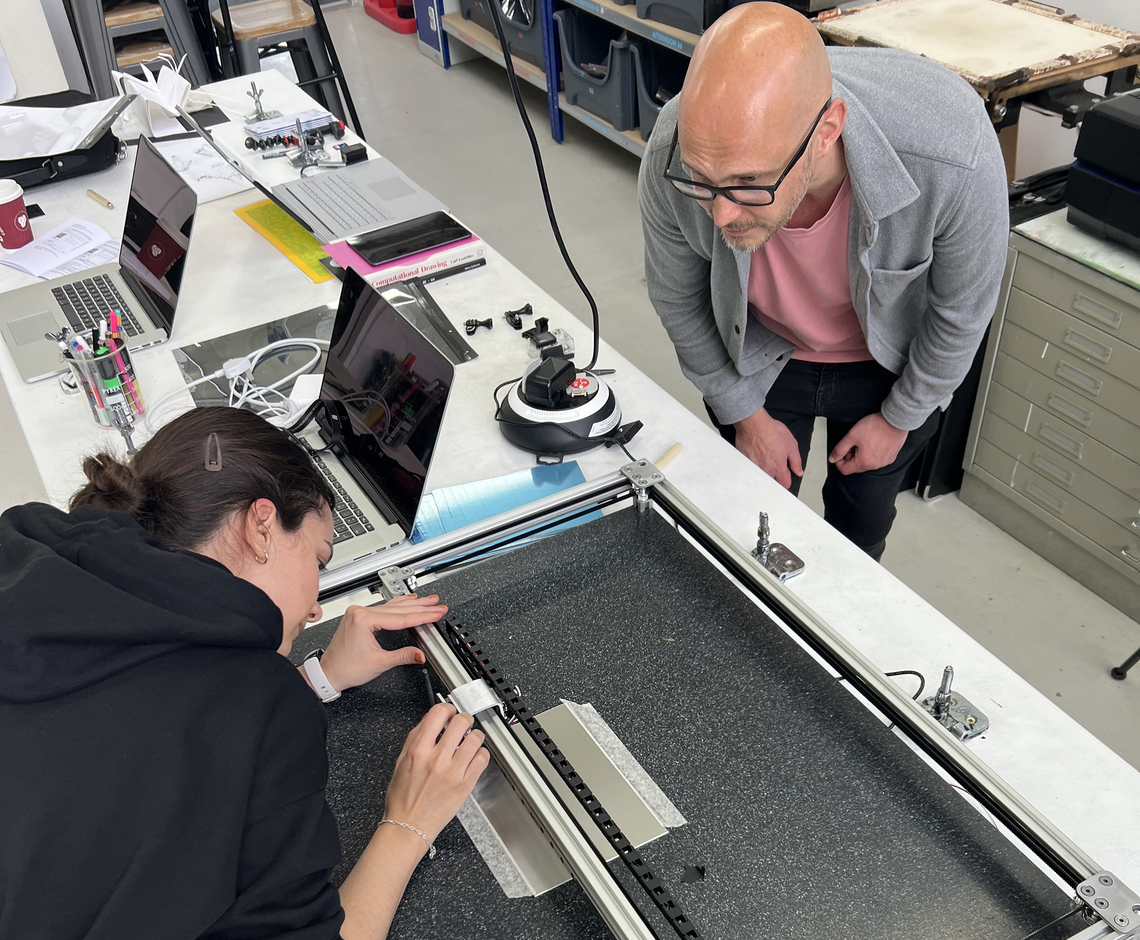 Two people are examining a prototype