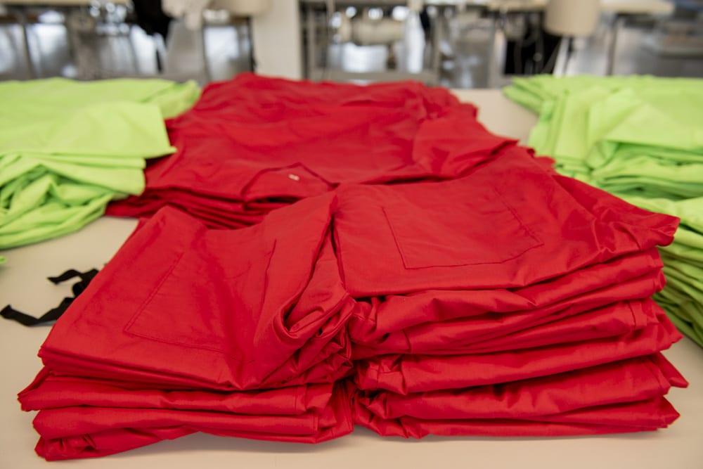 Piles of nursing scrubs folded up and arranged on a table
