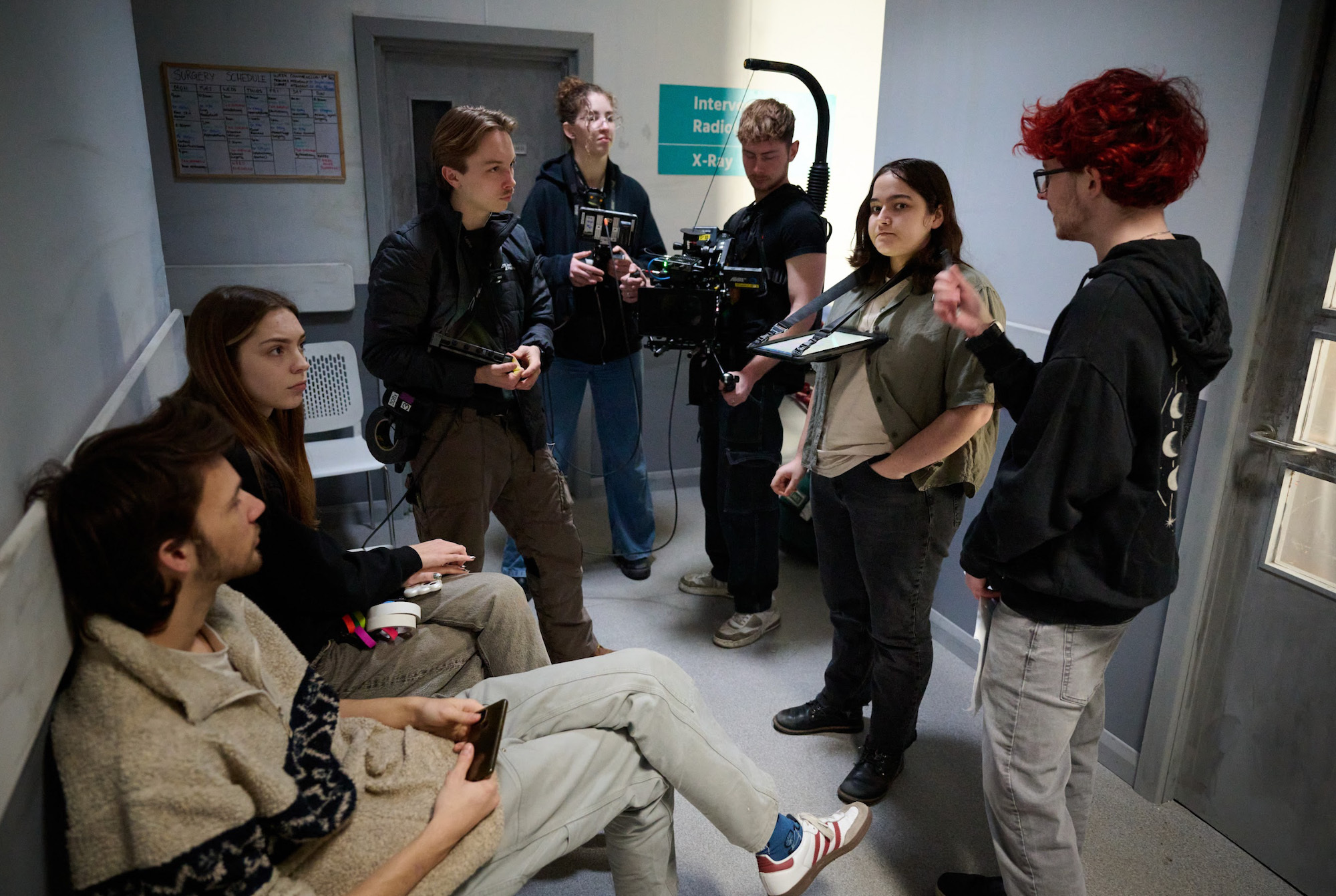 A group of BA (Hons) Film Production students in a corridor outside a hospital ward, on set of a graduation film.
