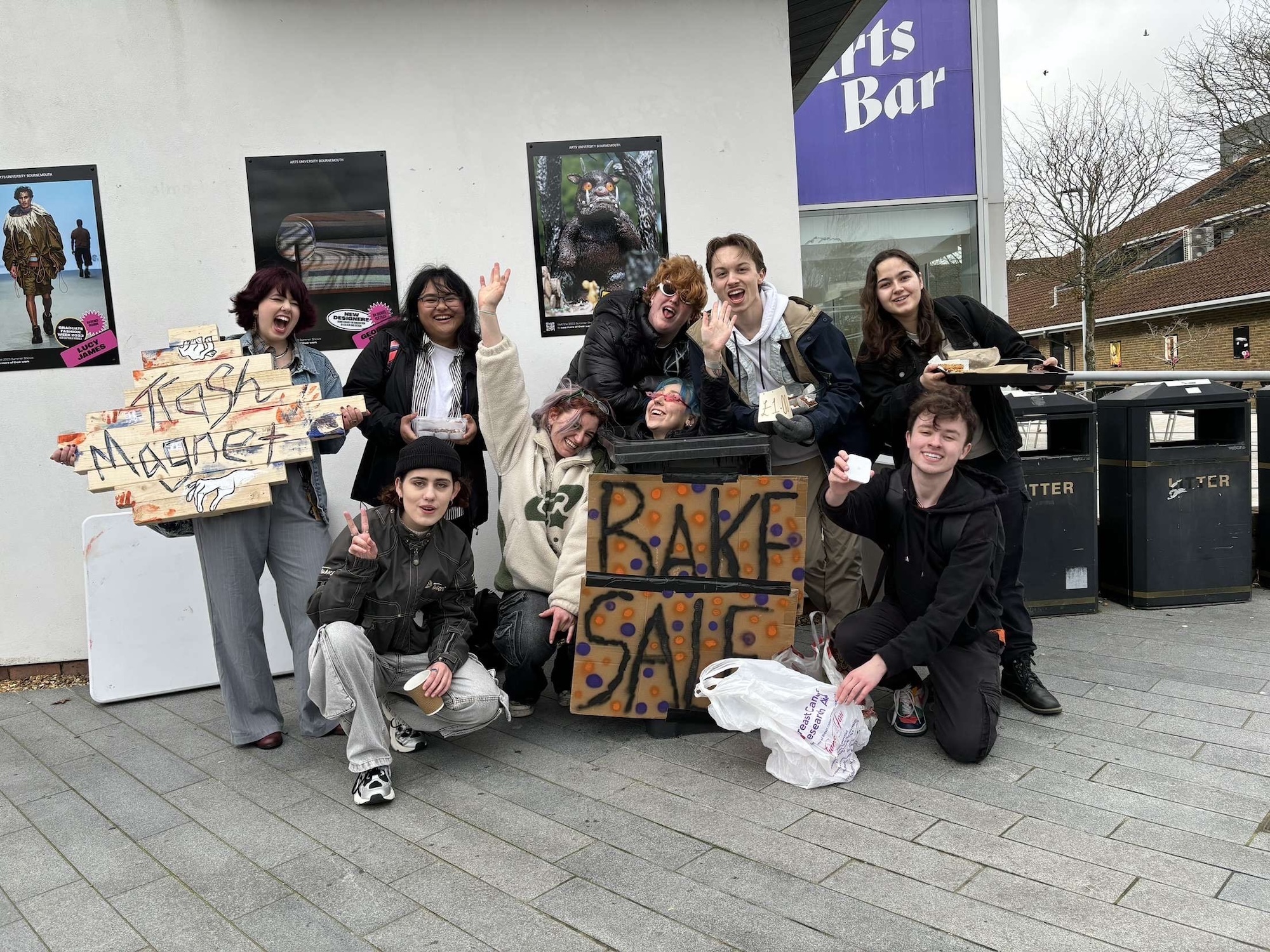 A group of BA (Hons) Film Production students pose for a photo on AUB campus as they advertise a bake sale fundraiser for the independent film "Trash Magnet".