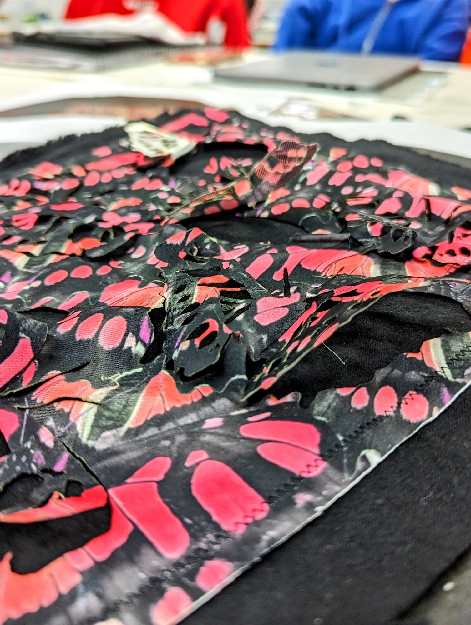 Close-up of a piece of textile with an abstract black and crimson pattern.