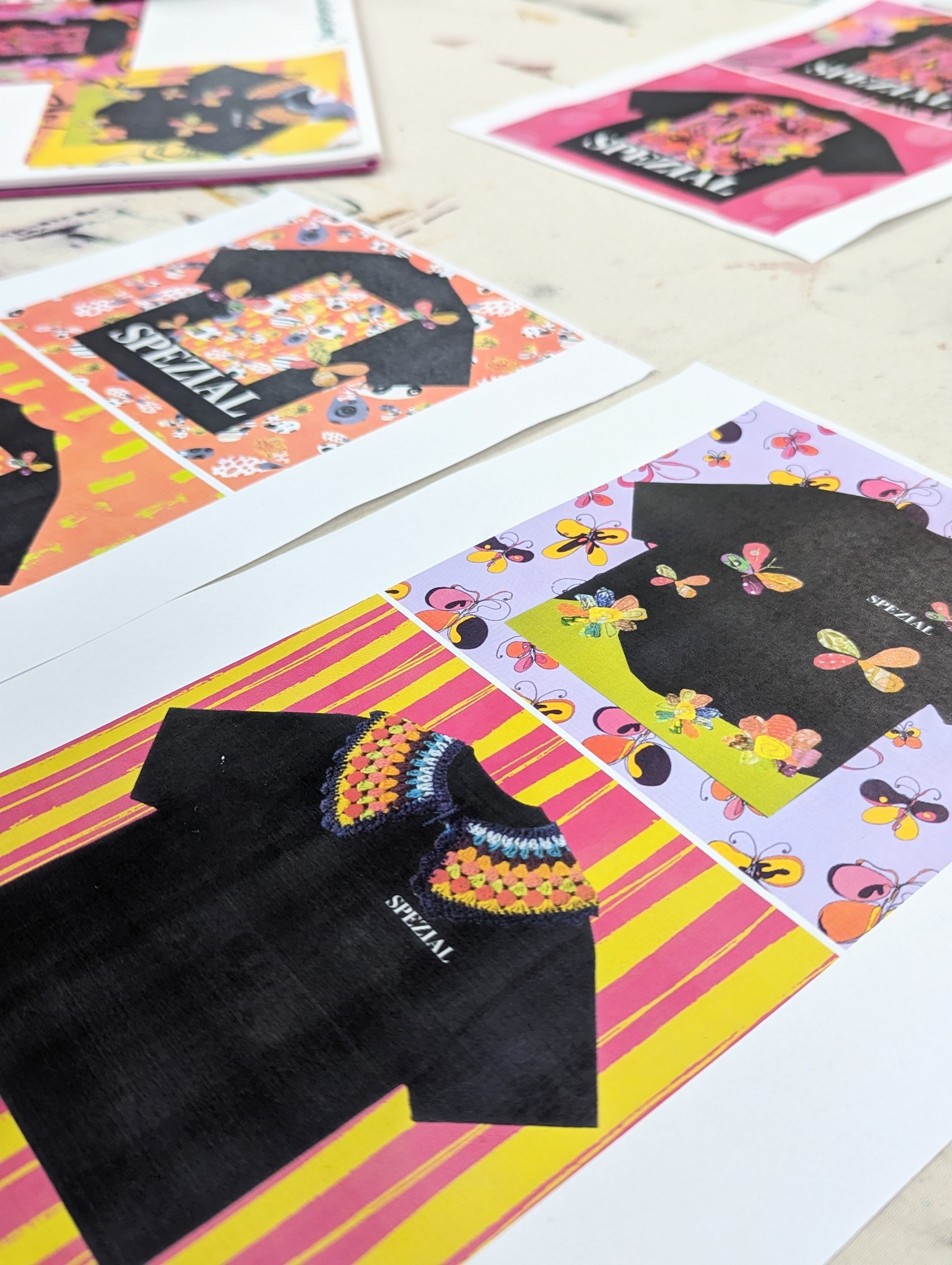 Close-up of several colourful T-shirt designs, two per piece of paper.