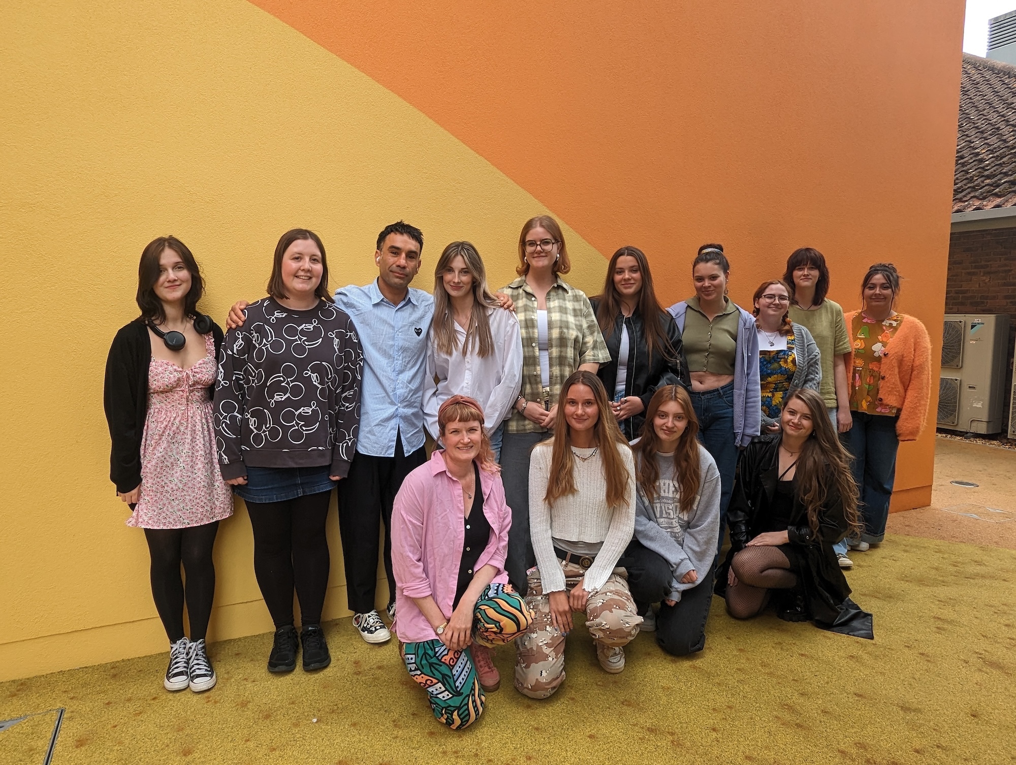 A group of BA (Hons) Textiles Design students posing for a photo outside the Innovation Studio on AUB Campus.