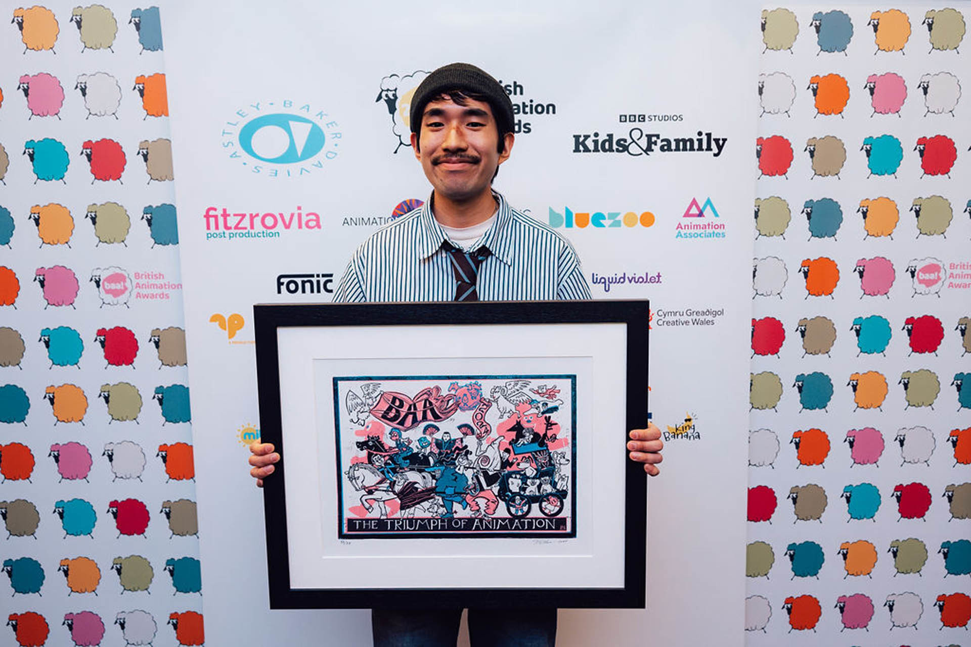 Filmmaker and BA (Hons) Animation Production alumnus S Miyazaki standing with his framed British Animation Award.