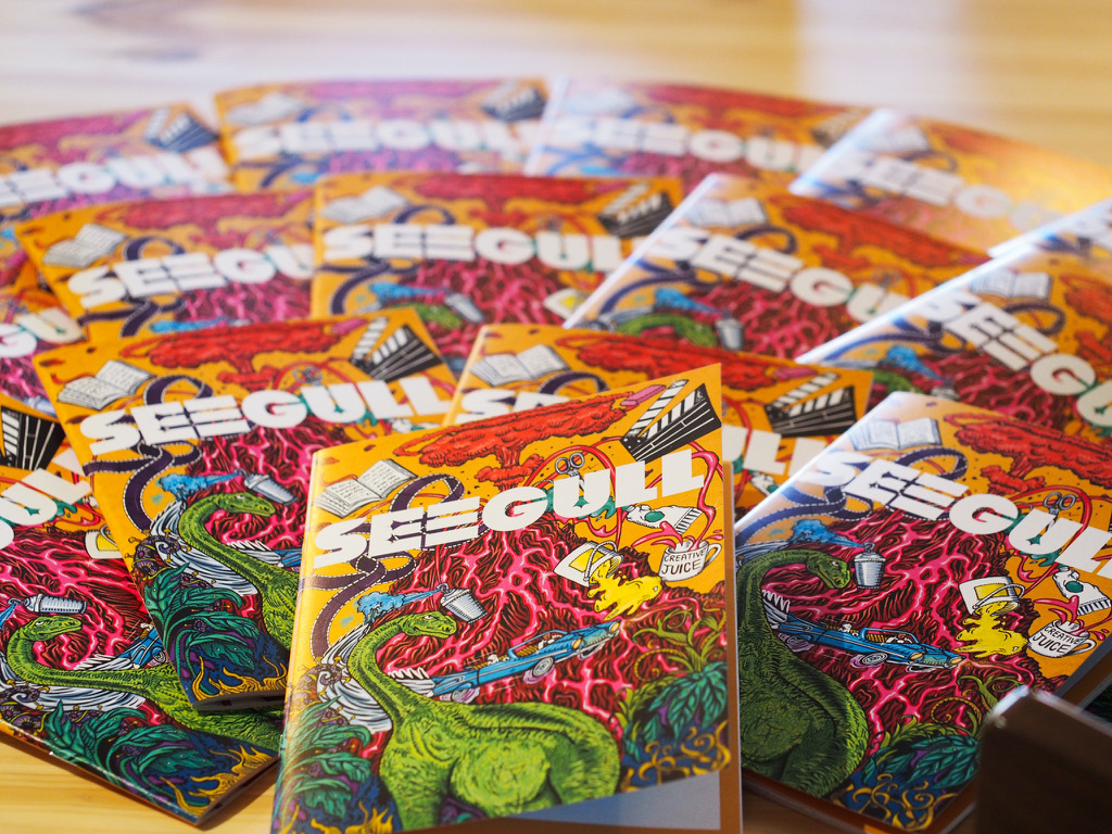 Multiple colourful comic book covers featuring green dinosaur character, arranged in overlapping rows with red and orange backgrounds.