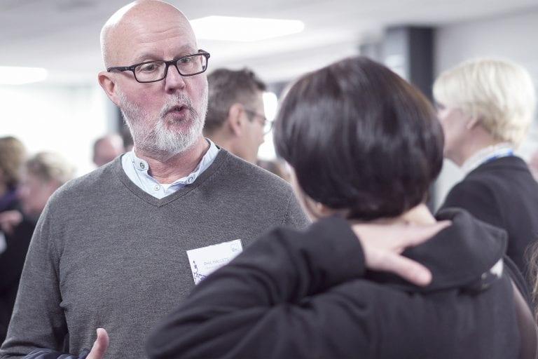 Two people talk in a gallery space