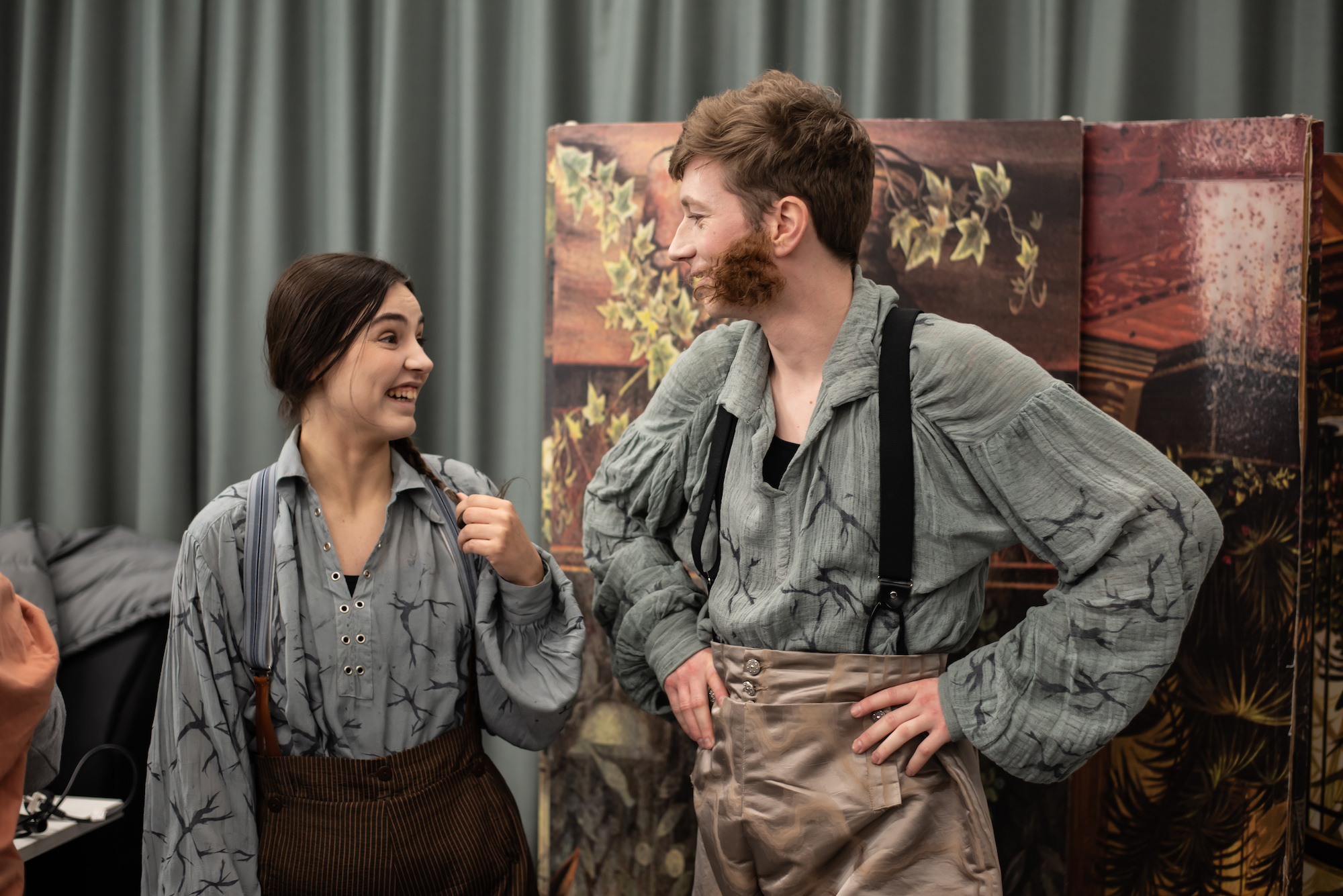 Two BA (Hons) Acting students in costume looking at one another behind the scenes for "The Wolves of Willoughby Chase".