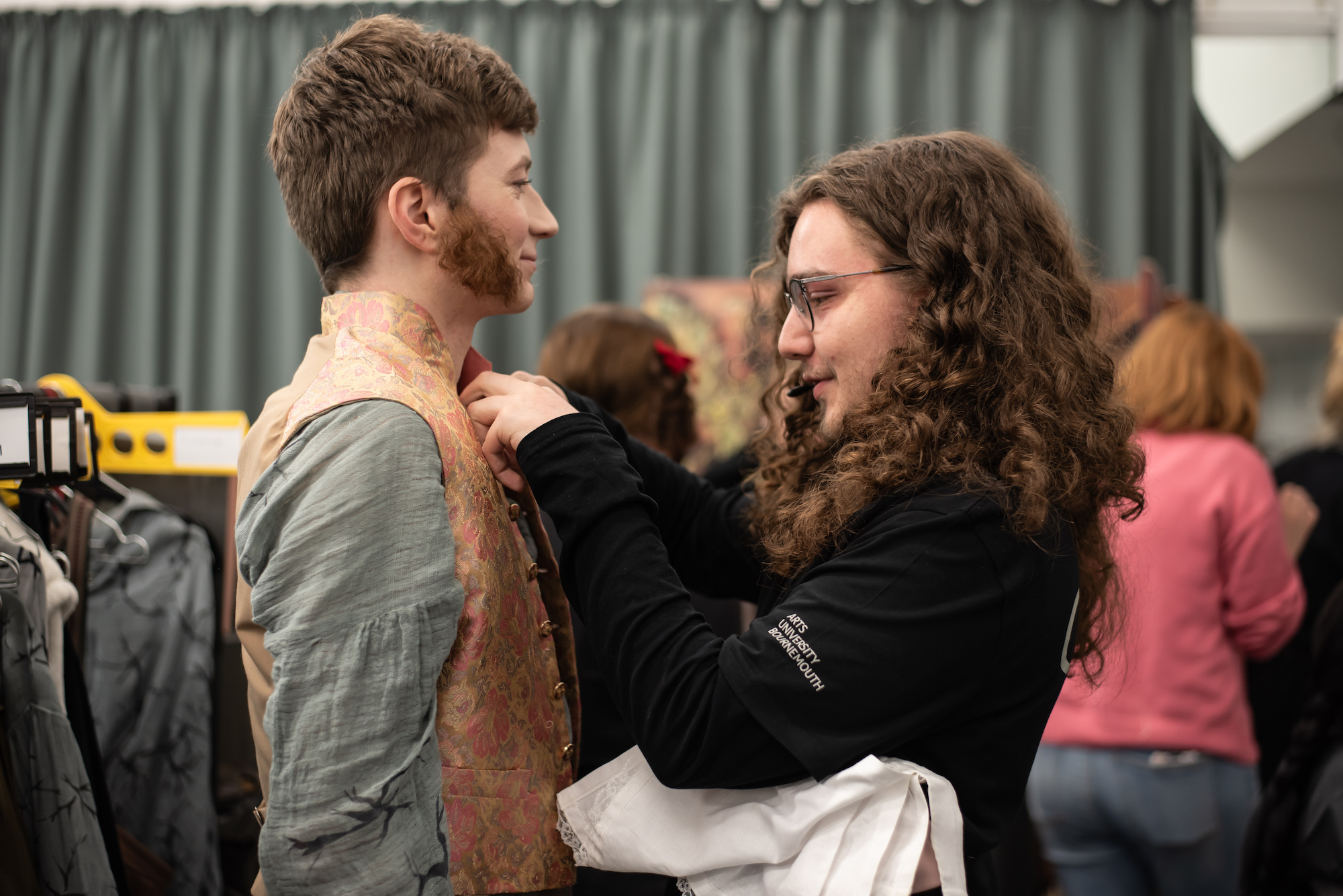 A BA (Hons) Costume student adjusts a BA (Hons) Acting student's costume backstage during a performance of "Wolves of Willoughby Chase".