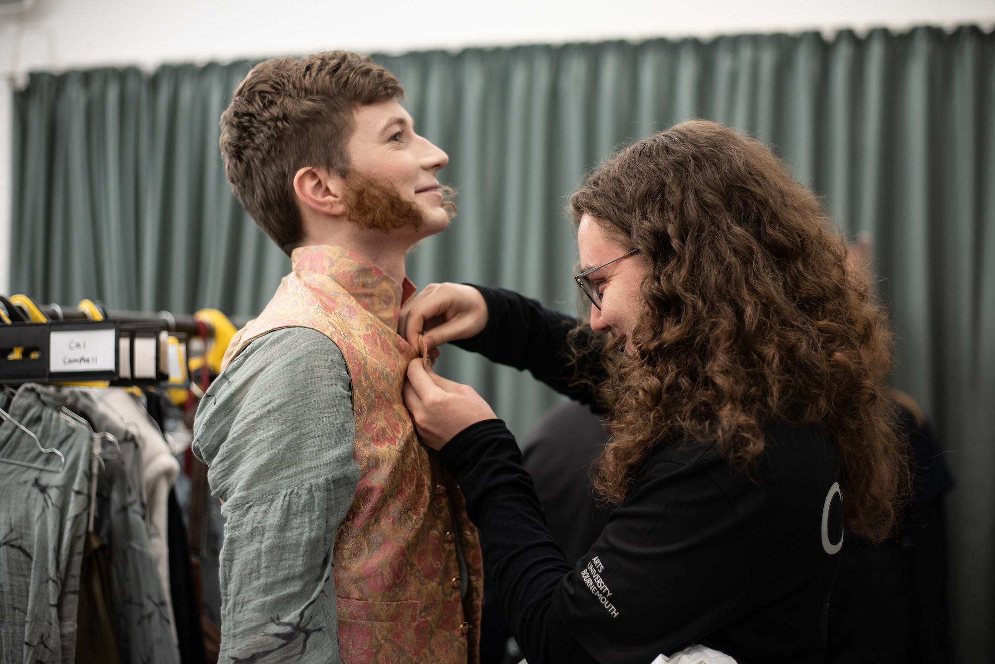 A BA (Hons) Costume student fits a waistcoat onto a BA (Hons) Acting student, behind the scenes on "The Wolves of Willoughby Chase".