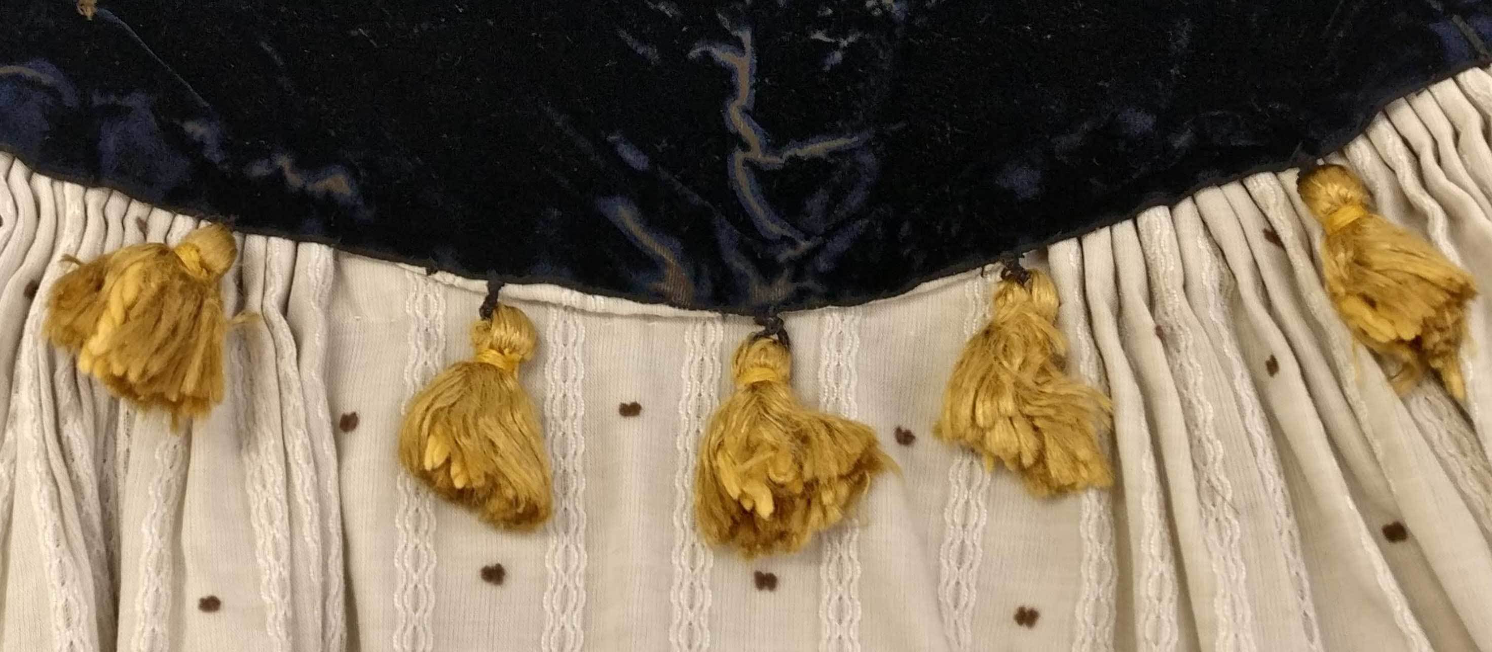 Close-up of a garment with a row of tassels.