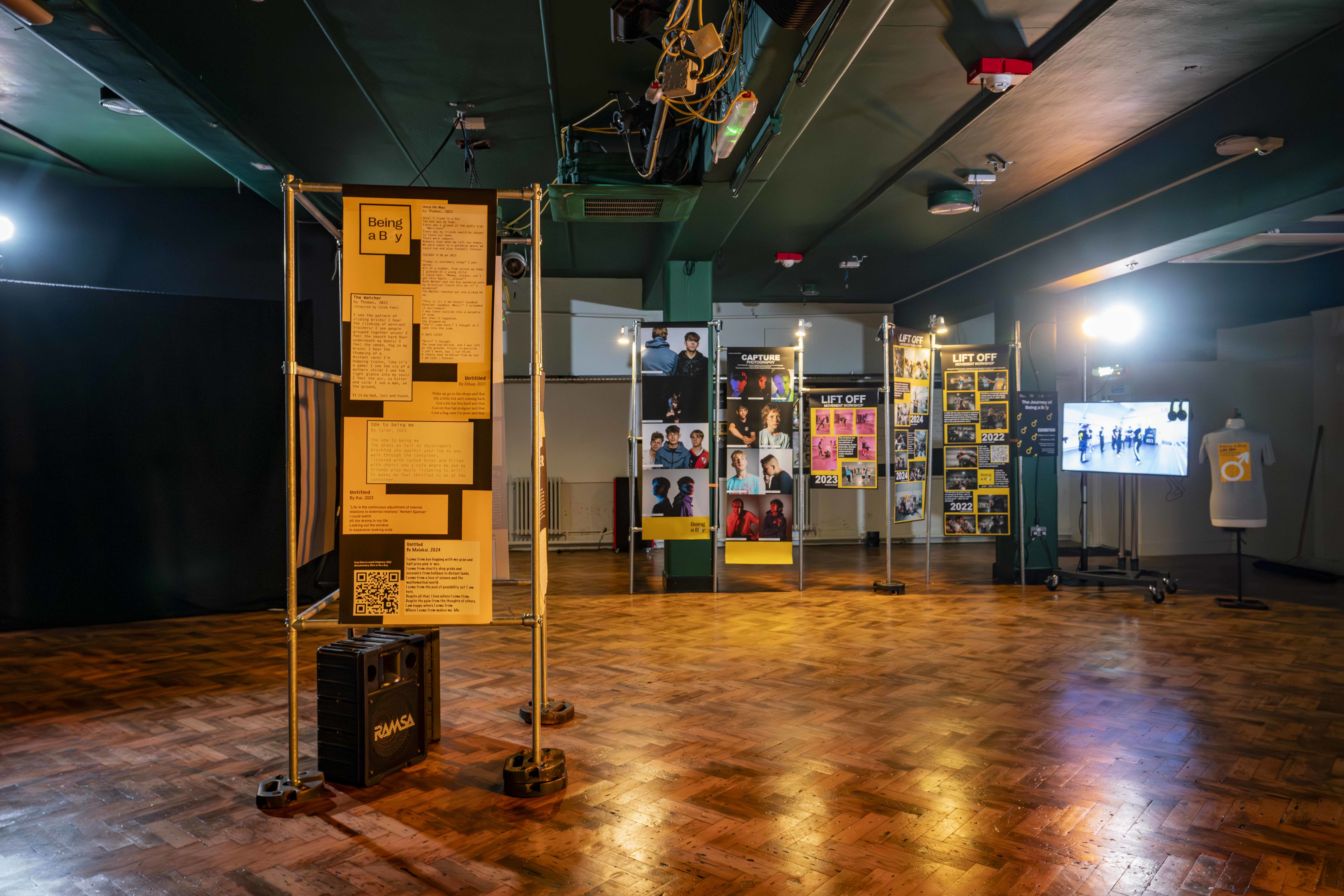 A series of banners and posters on stands as part of the Journey of Being a Boy exhibition at Palace Court Theatre.