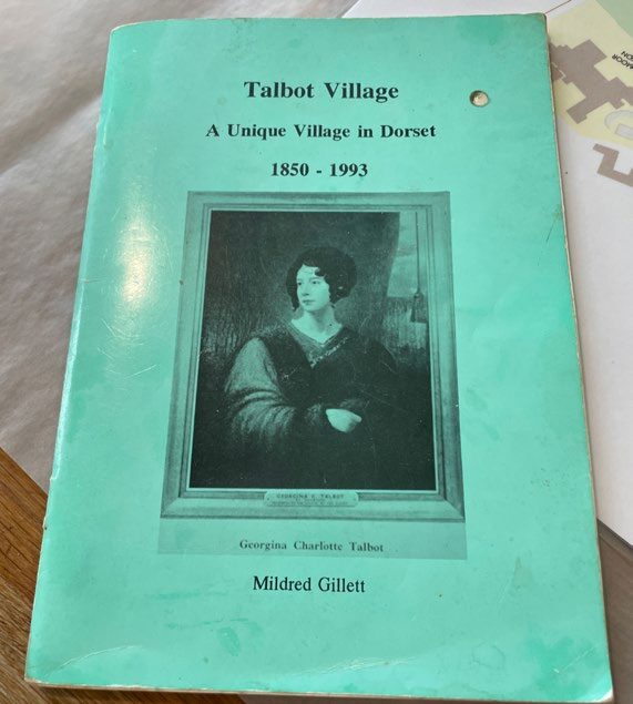 Turquoise book cover titled "Talbot Village: A Unique Village in Dorset 1850-1993" by Mildred Gillett with sepia portrait photograph.