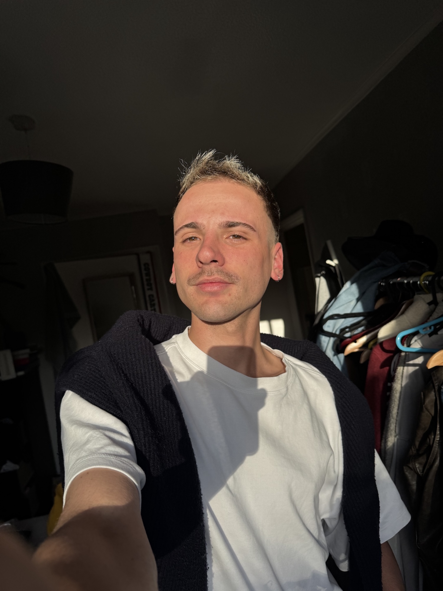 B Bolland taking selfie inside vehicle with green ceiling and dark interior.
