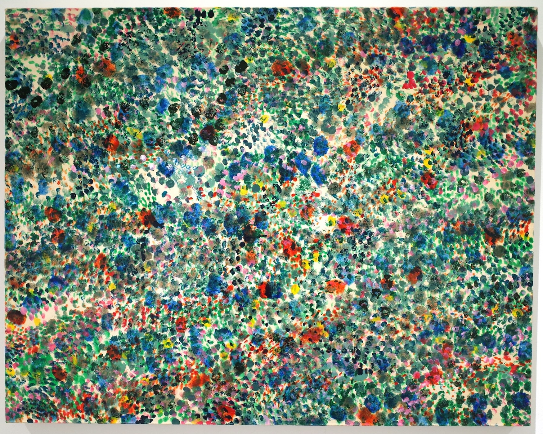 Abstract painting with dense multicoloured paint splatters and dots covering entire canvas. Dominant greens and blues with scattered red, yellow, white, and black marks throughout.