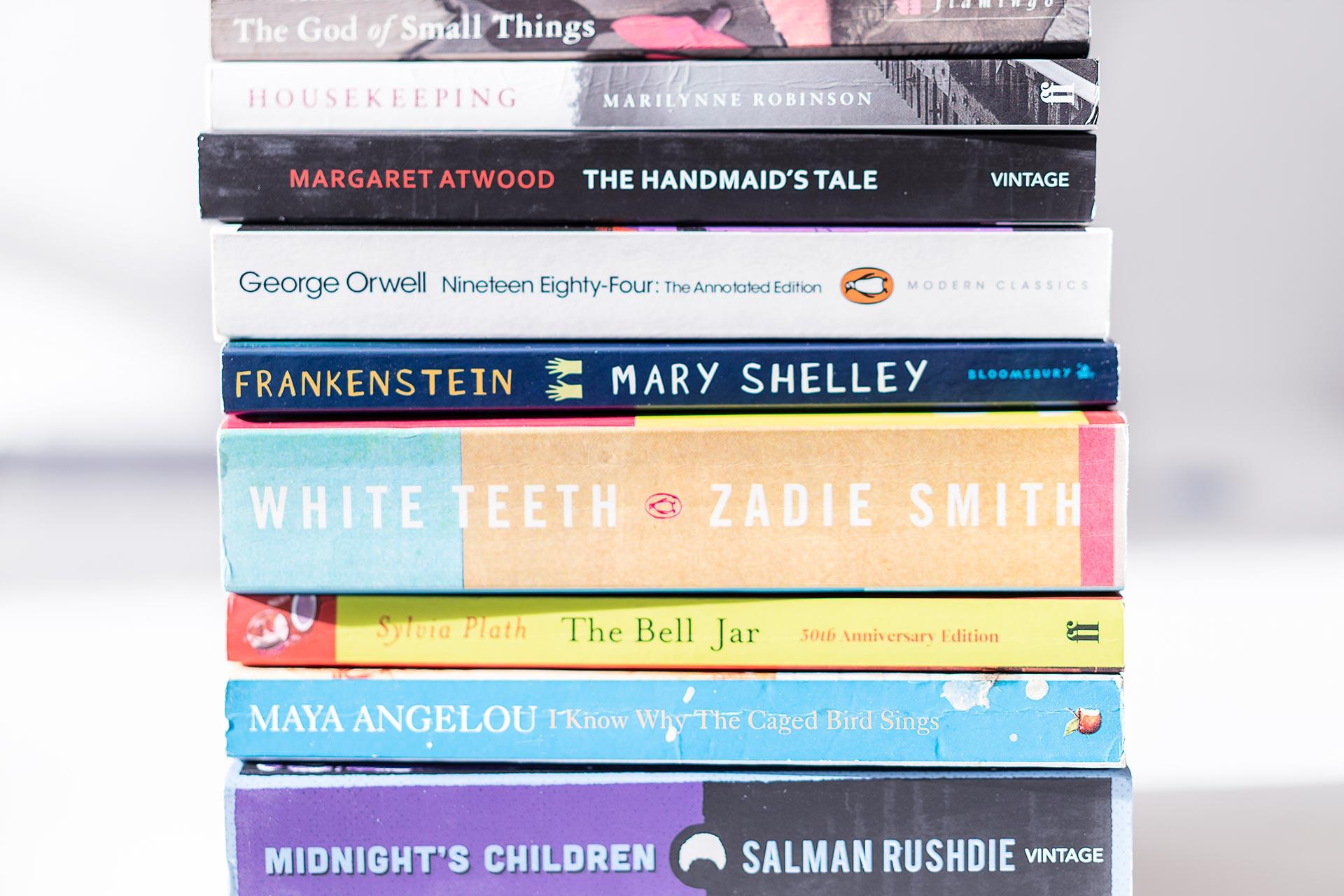 Close-up of a stack of books with their spines and titles facing the front.
