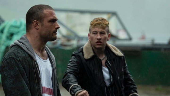 Still from the film Calm With Horses, showing two men in costume looking at one another.