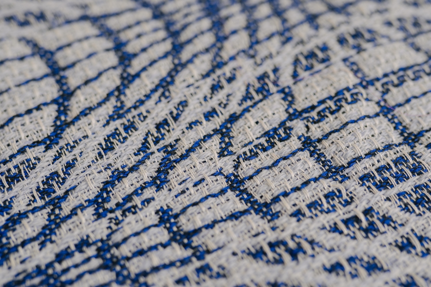 Close-up of cracked concrete surface with deep blue lines forming irregular geometric patterns on grey background.