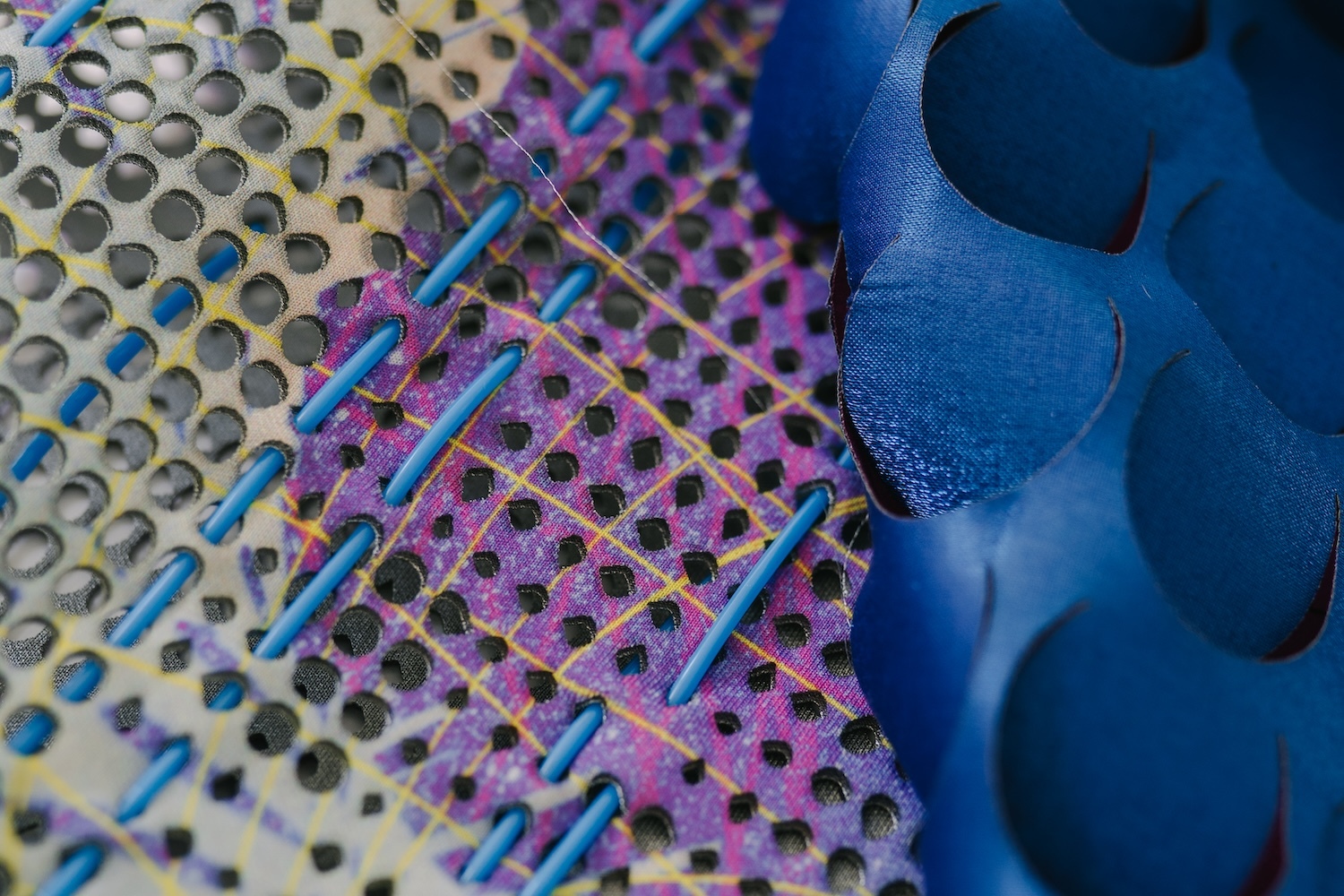 Abstract composition with blue curved shapes on right, purple and yellow dotted patterns on left, intersected by diagonal blue lines.