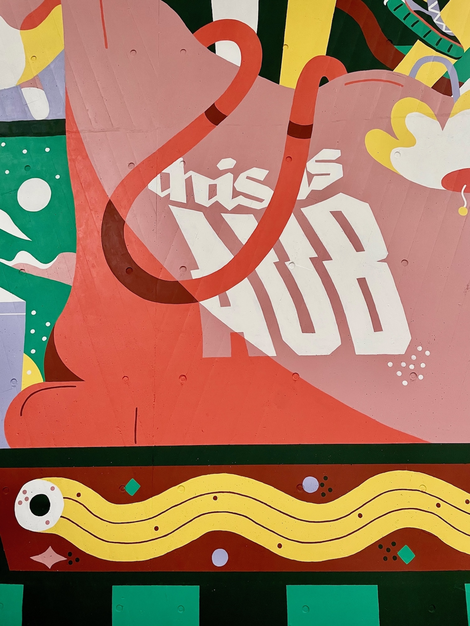 Part of a mural on a flyover pillar wall; colourful illustration of an abstract red and pink object with text reading "this is AUB" on it. Underneath, an eye-shaped object with a yellow and purple wavy stream coming out of it.