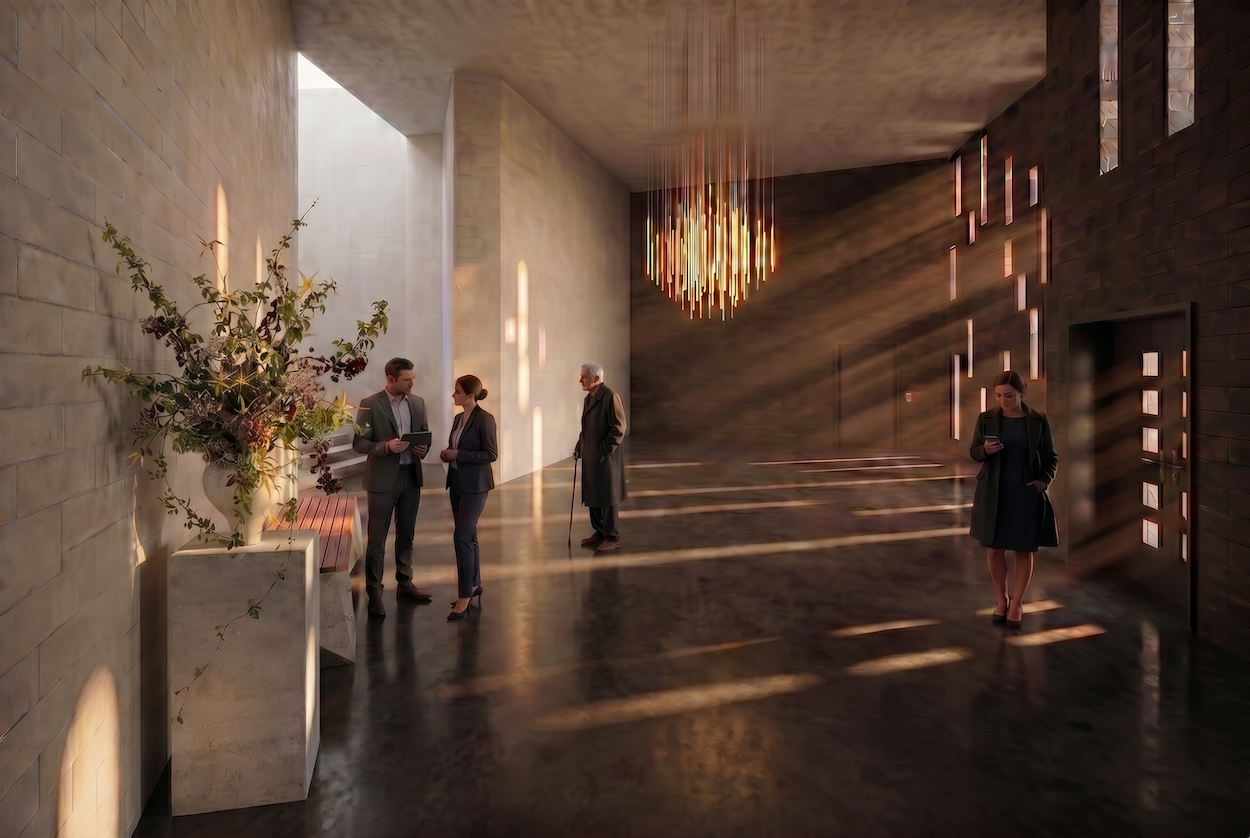 A spacious hallway in a crematorium building. Four people are waiting there. Sunlight shines into the hallway through windows on the right-hand side. A vase of flowers sits on a marble pedestal in the foreground.