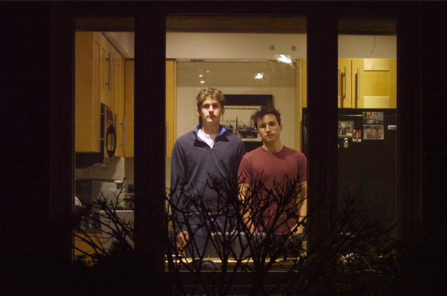 AUB Foundation graduate Charlie Hill standing next to filmmaking partner Max Mezo at a window.
