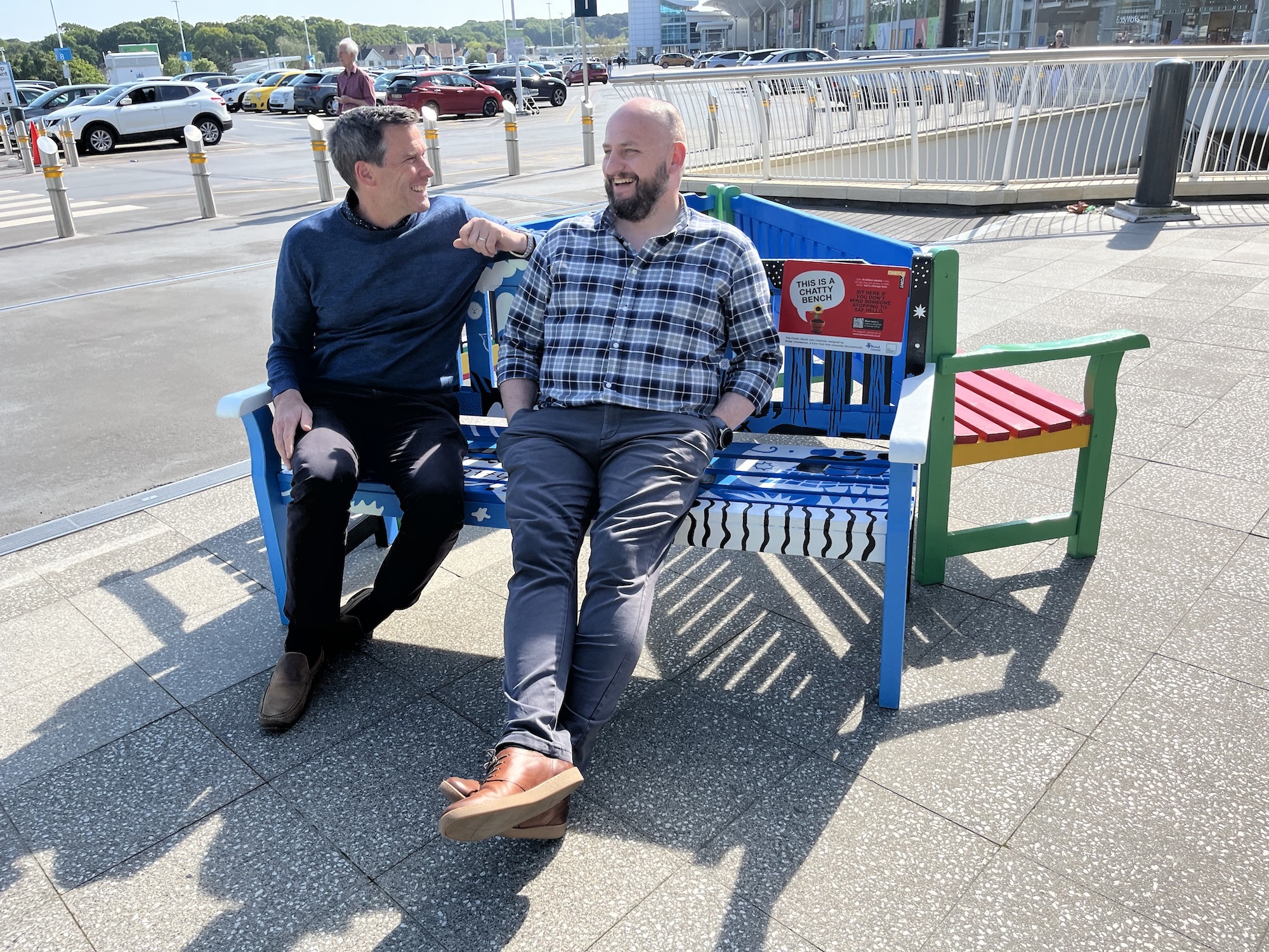 Two men sit and chat on one of the "Chatty" benches by Castlepoint car park.