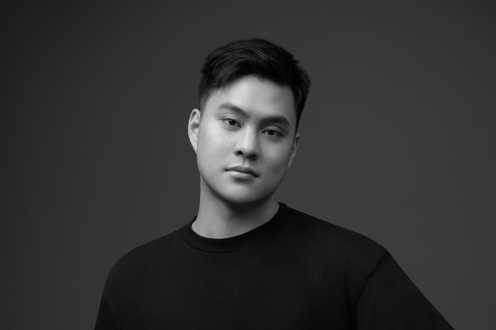 Black and white portrait of C-J Liu against grey backdrop, looking slightly left of camera.