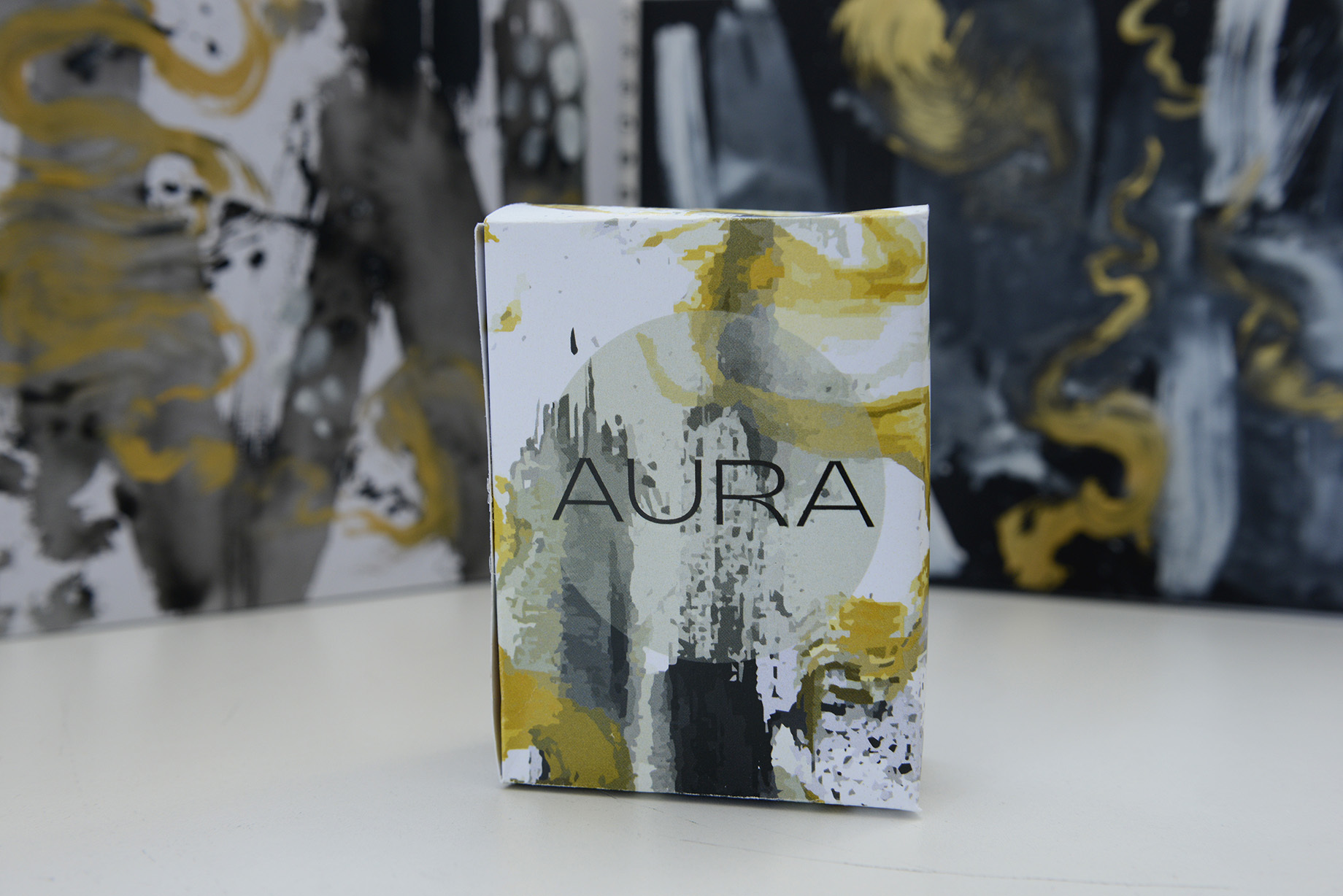 Packaging box for 'Aura' rests on a plain surface.