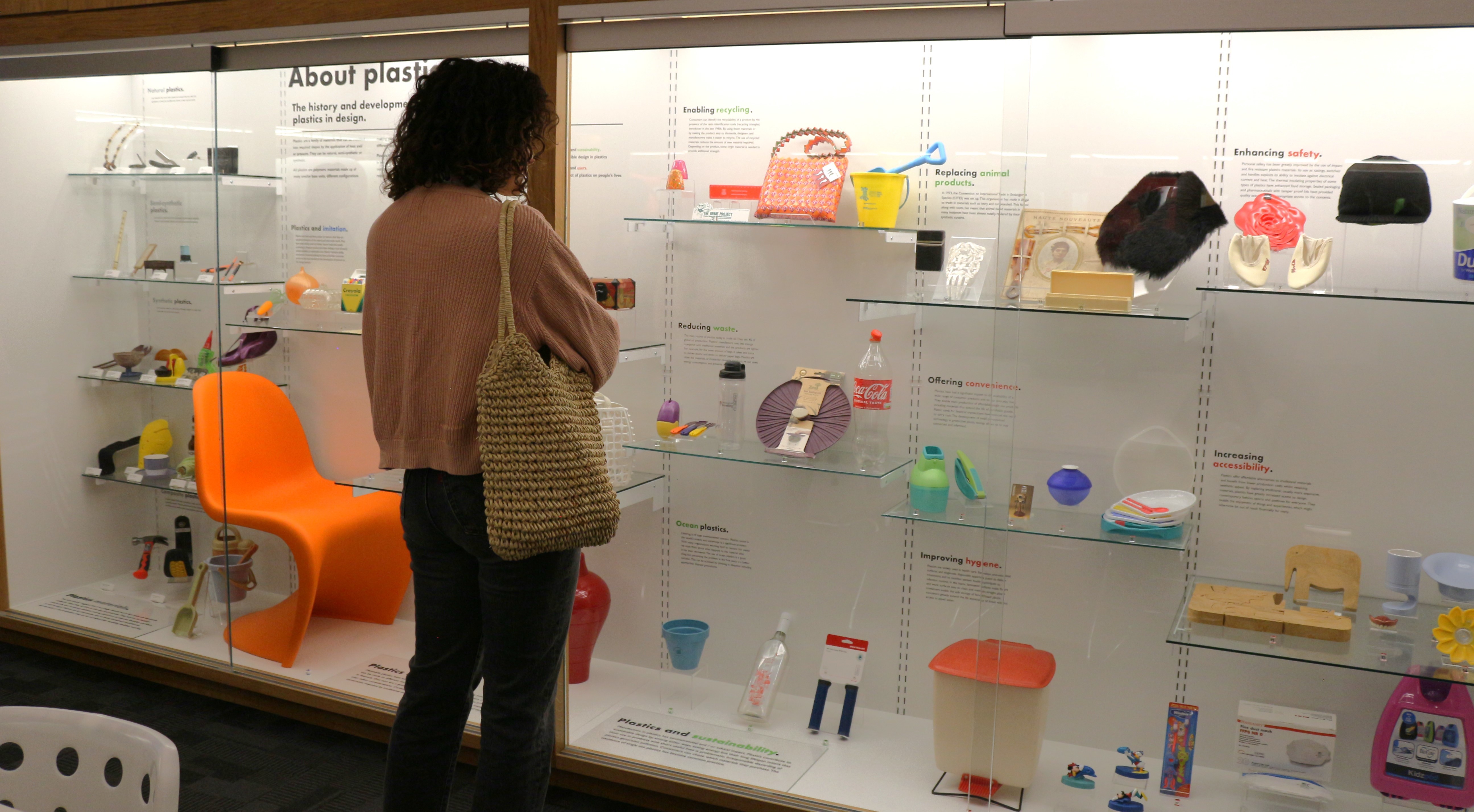 A visitor looks at a large display case with various plastic objects, as part of an exhibition at the Museum of Design in Plastics (MoDiP) at Arts University Bournemouth.