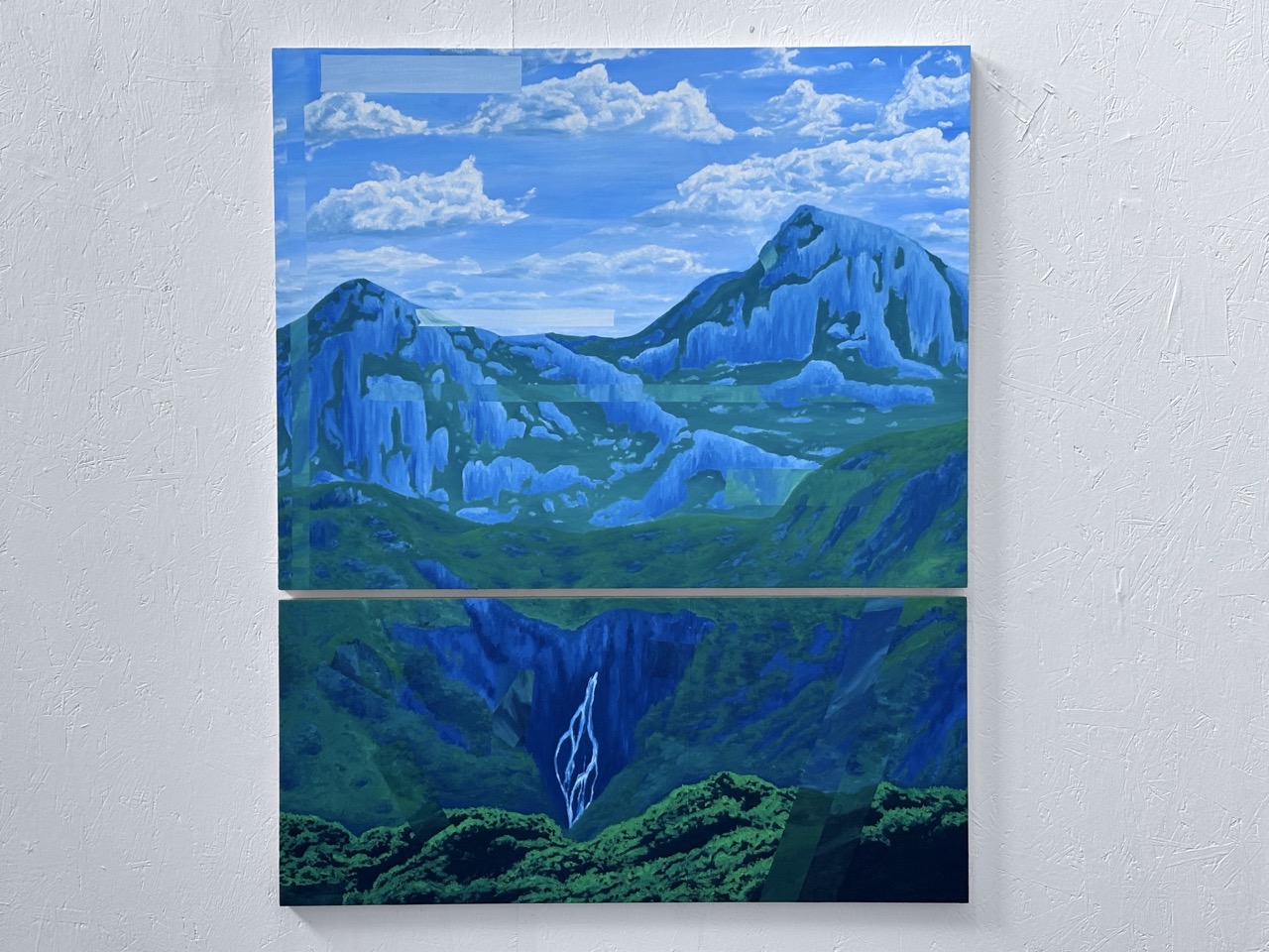 A two-panel painting depicting a mountainous landscape with vibrant blue hues. The top panel shows mountains under a partly cloudy sky, while the bottom panel features a waterfall cascading down into a lush green valley.