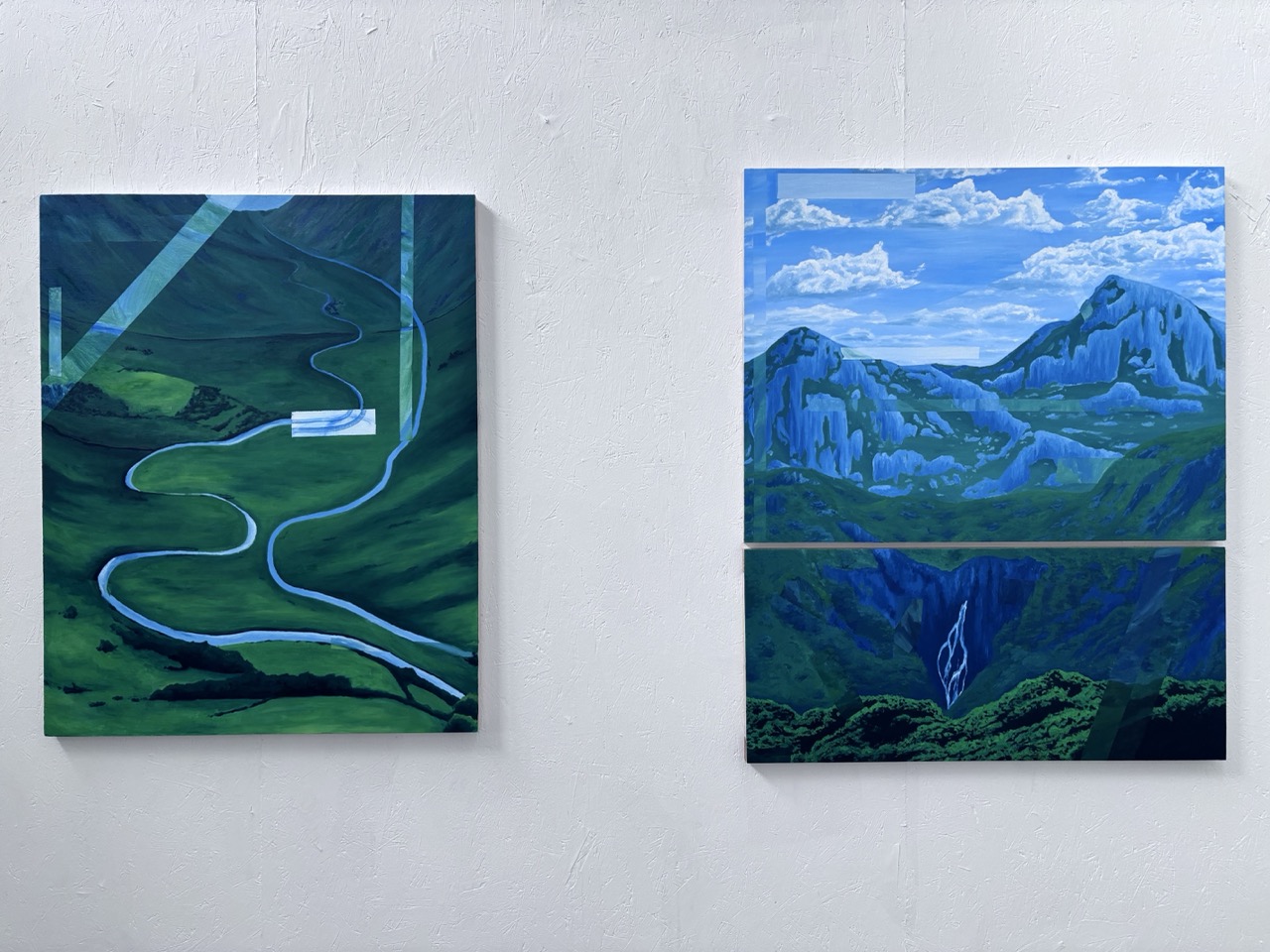 Two abstract landscape paintings displayed on a white wall. The left painting features a winding river through green hills, while the right painting depicts a mountain range under a blue sky with clouds, separated by a horizontal line.