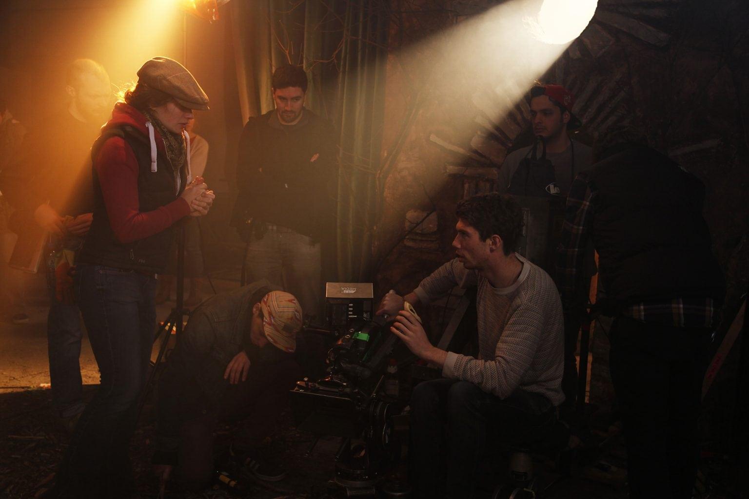 Film crew gathering around a camera