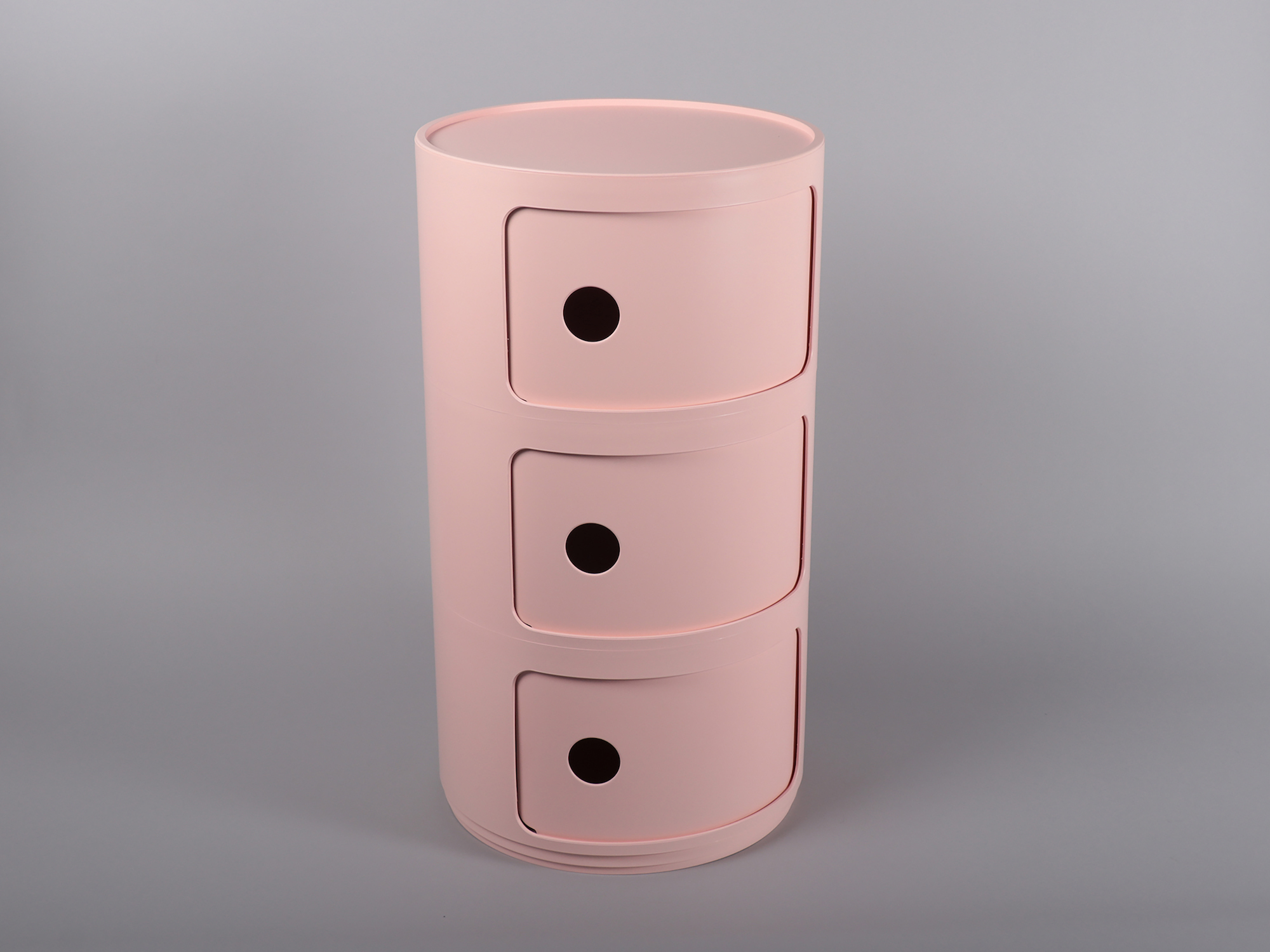 A plastic pink cylinder with three doors.