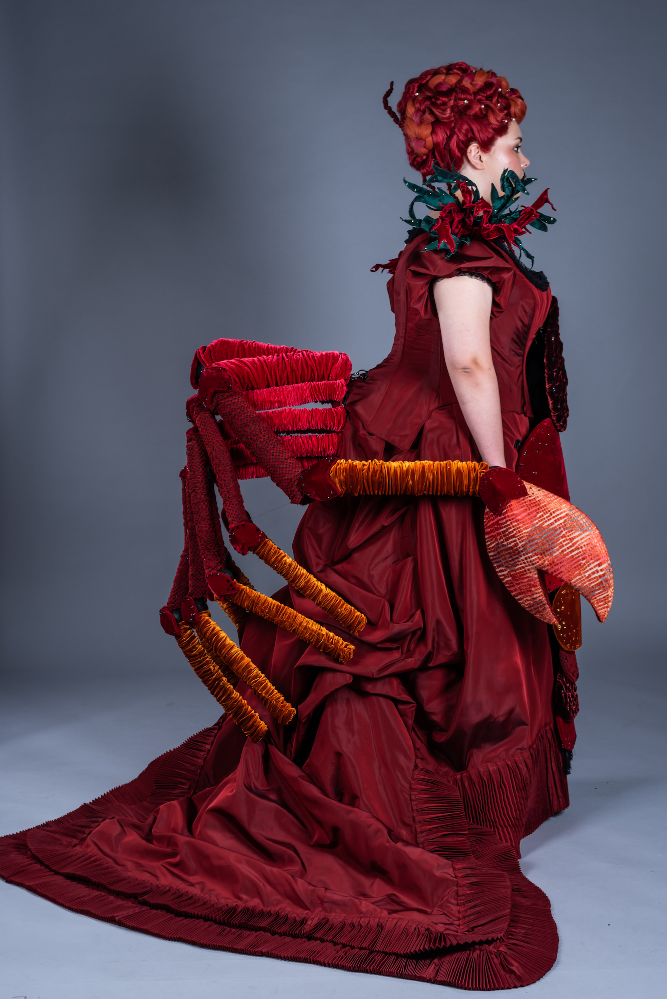 A model shown side-on, wearing a 19th century lobster-inspired dress.