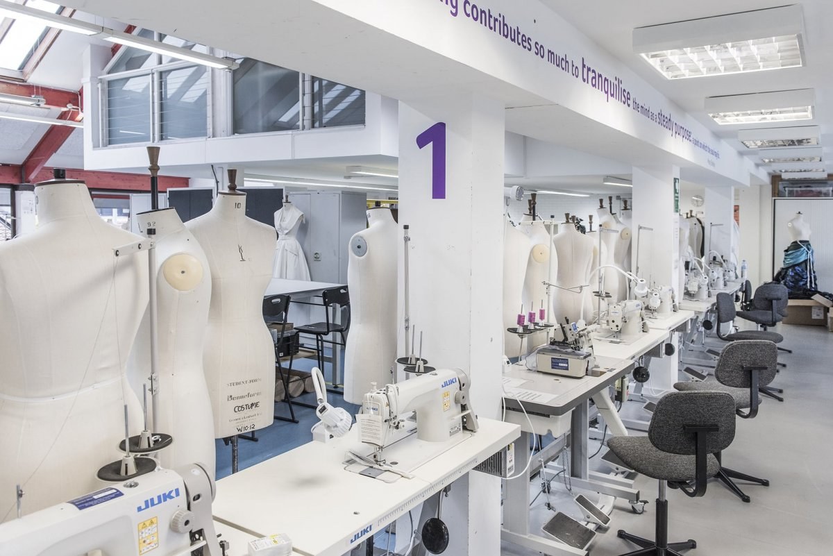 A row of mannequins and sewing machines in a costume design studio.