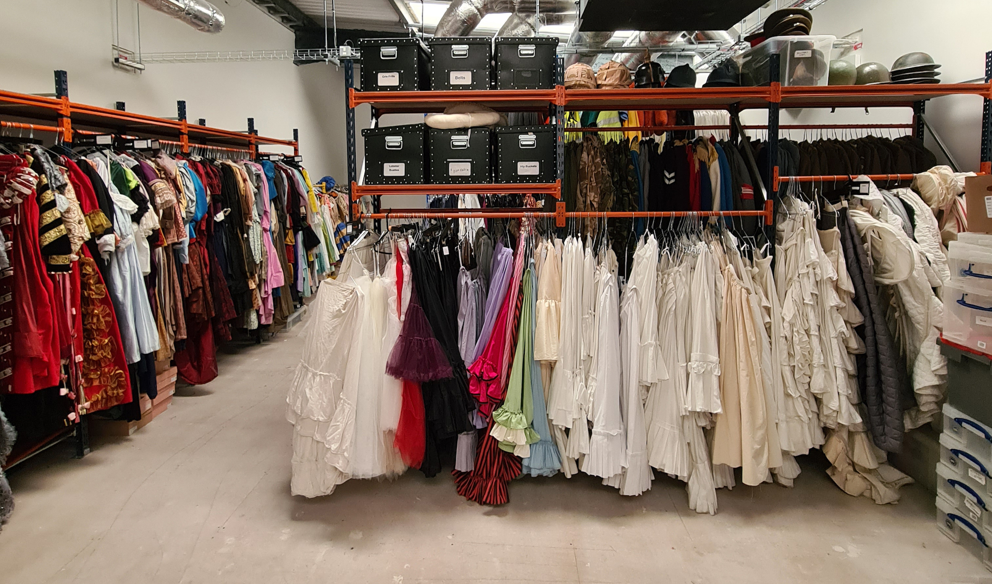 Inside one of AUB's costume stores, with rails of costumes and shelves with boxes, hats and helmets sitting on them.