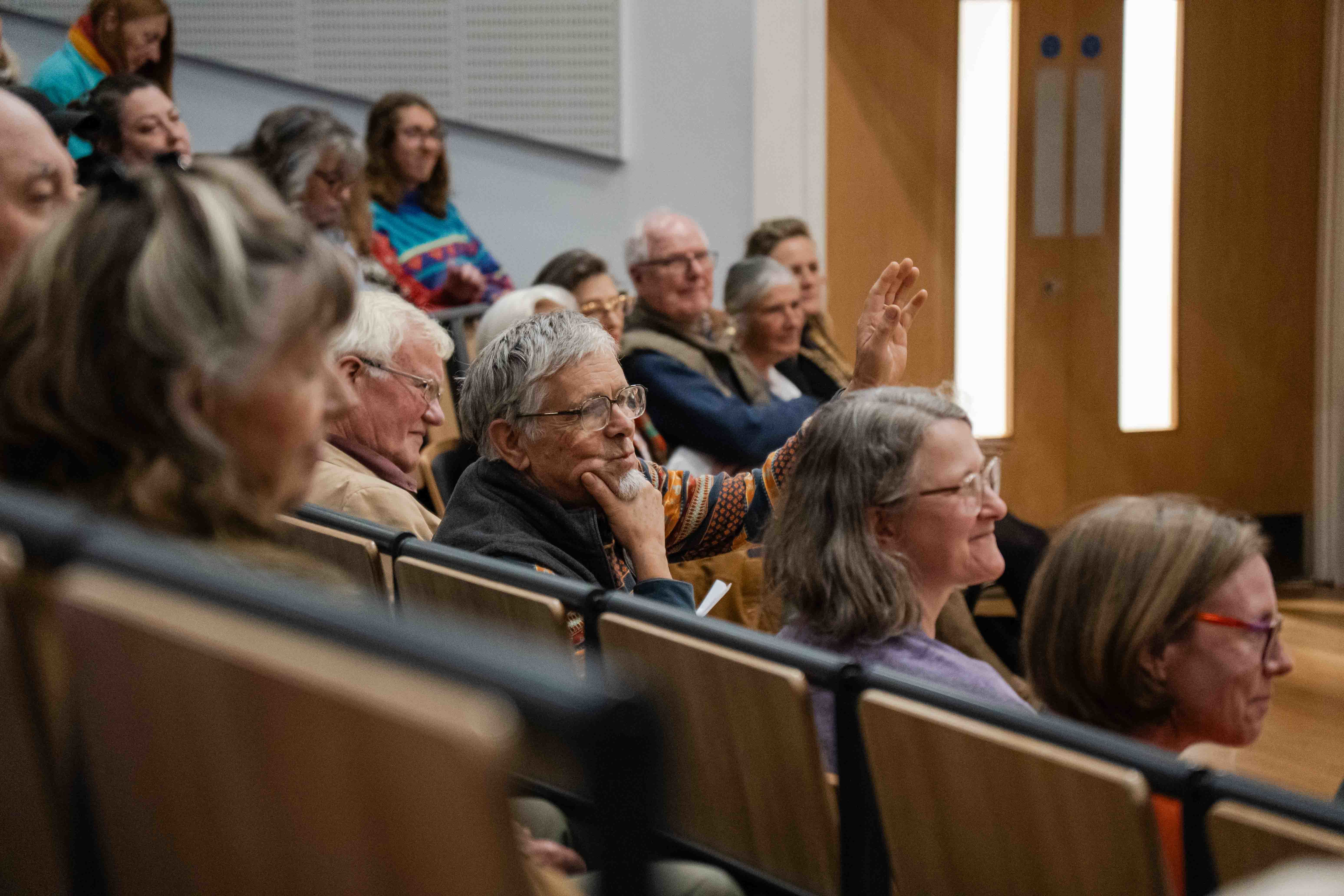 Close-up of audience members sitting in a university lecture theatre.