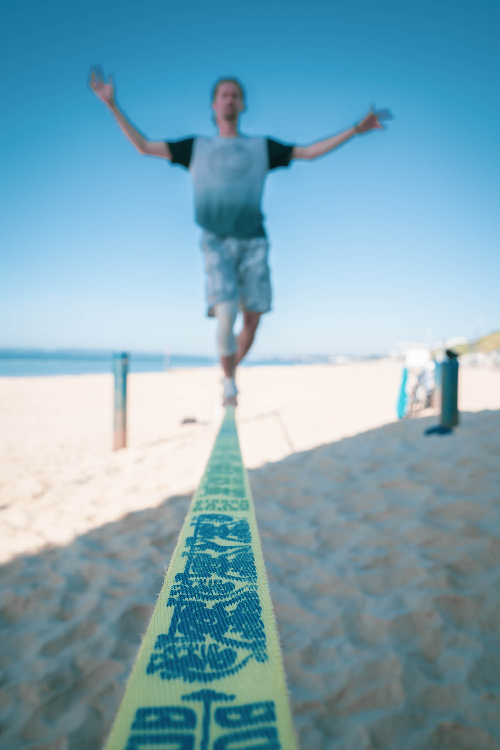 A slack liner playing on the beach