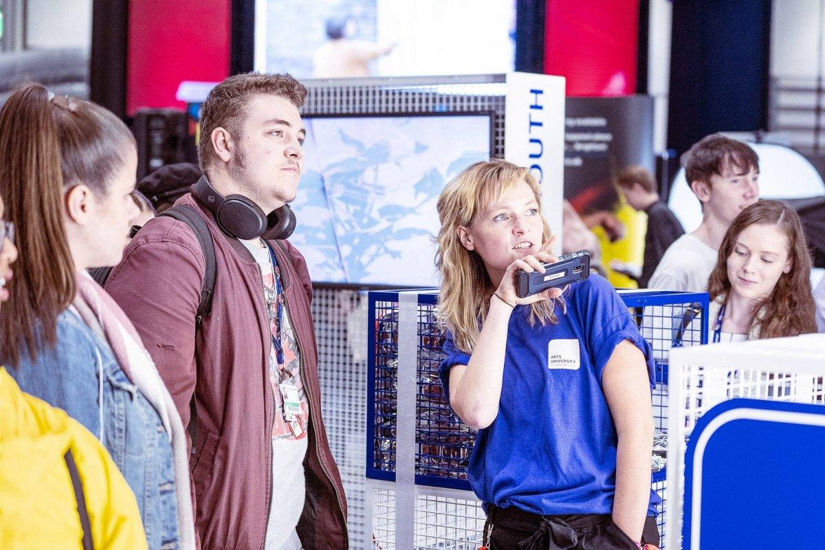 Student ambassador standing with someone and pointing to something off-camera.