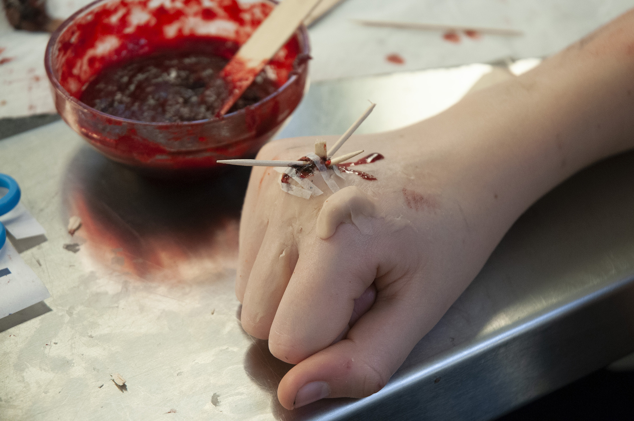 A hand with a cocktail stick protruding from the skin
