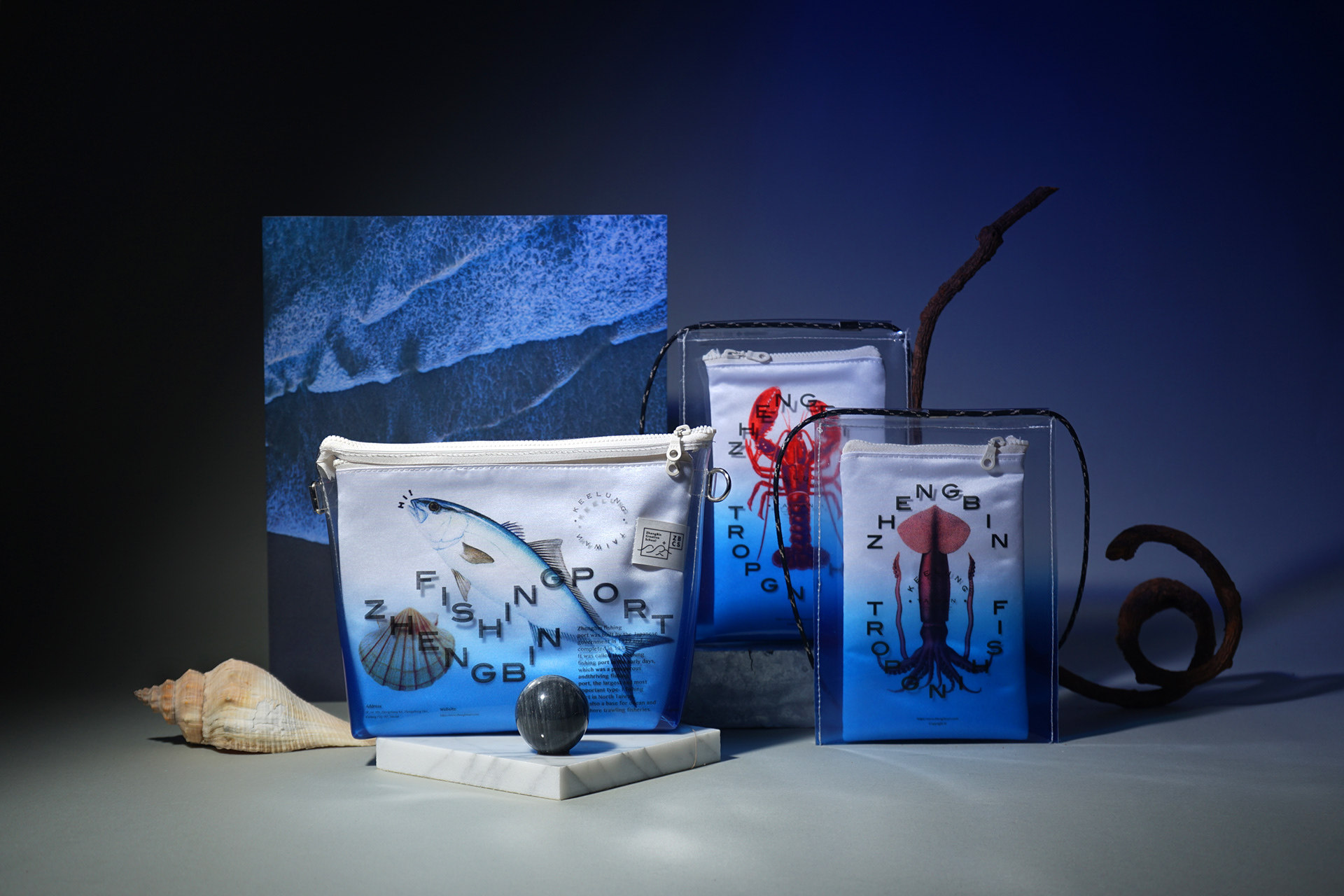 Three bags with the words "Zhengbin Fishing Port" and different sea creatures – a fish, a lobster, a squid – on them.