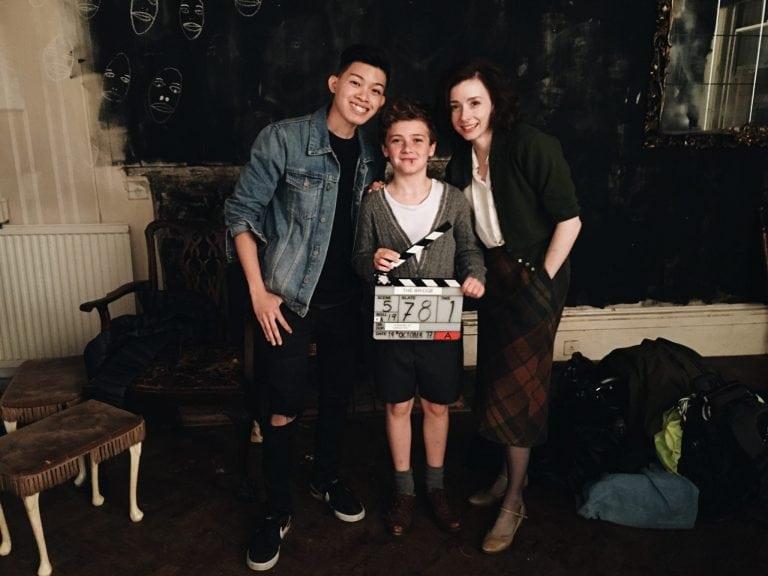 Darius Shu, Fiona Glascott and Austin Taylor stand and pose for a photo. Austin Taylor holds a clapper board.