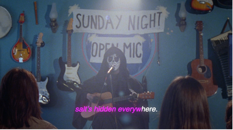 Still from BA (Hons) Film Production student commercial "Death's Open Mic", showing a person dressed as the Grim Reaper playing the guitar and singing.