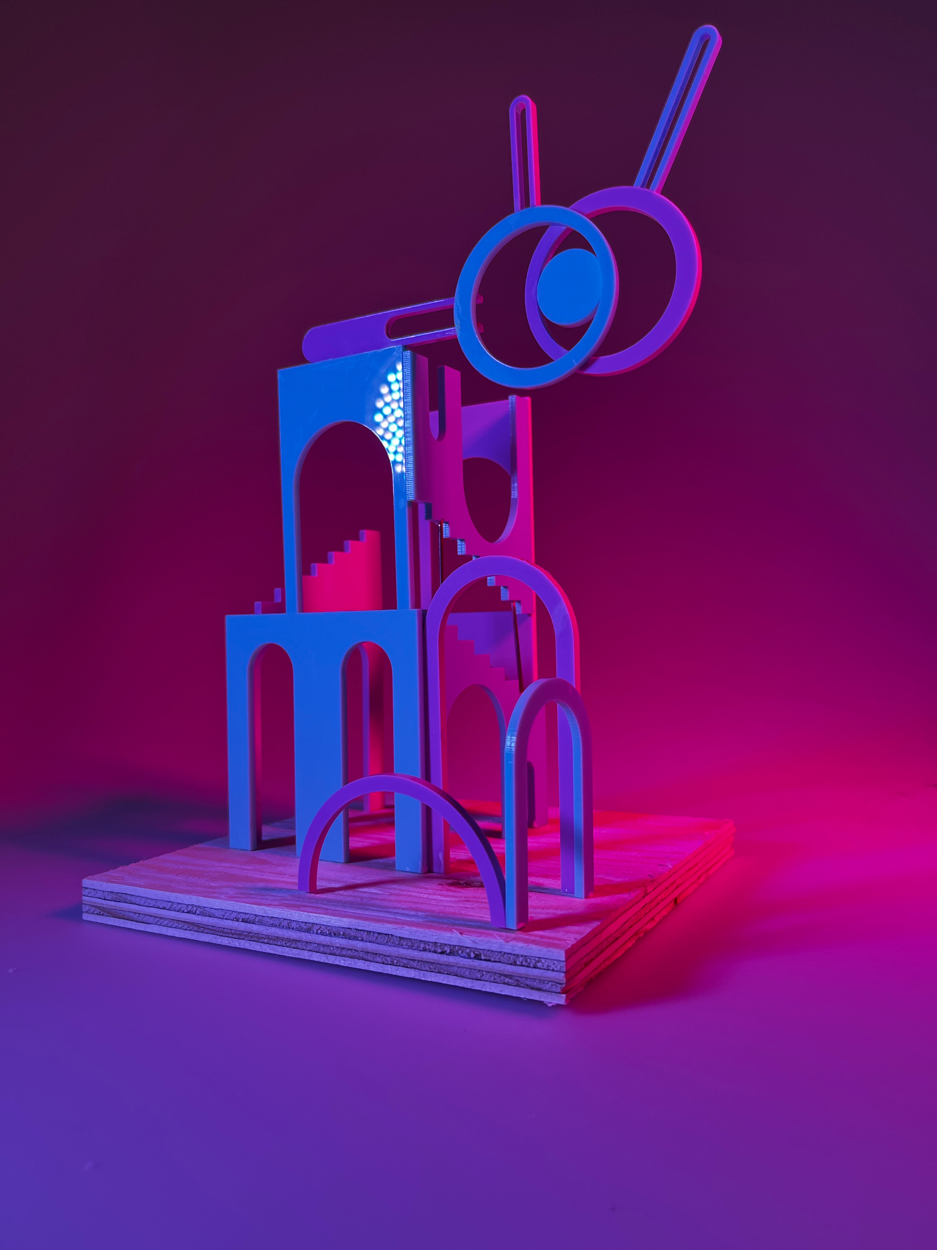 An abstract, structural model under blue and pink lighting, studio photography.