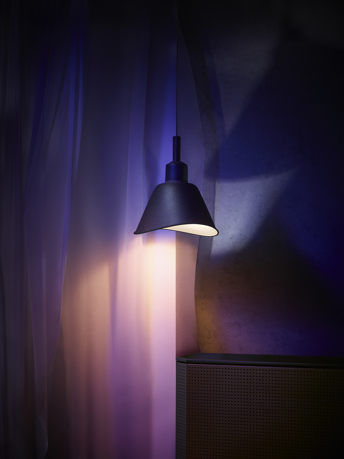 A dark, hanging lamp on a dark blue background.